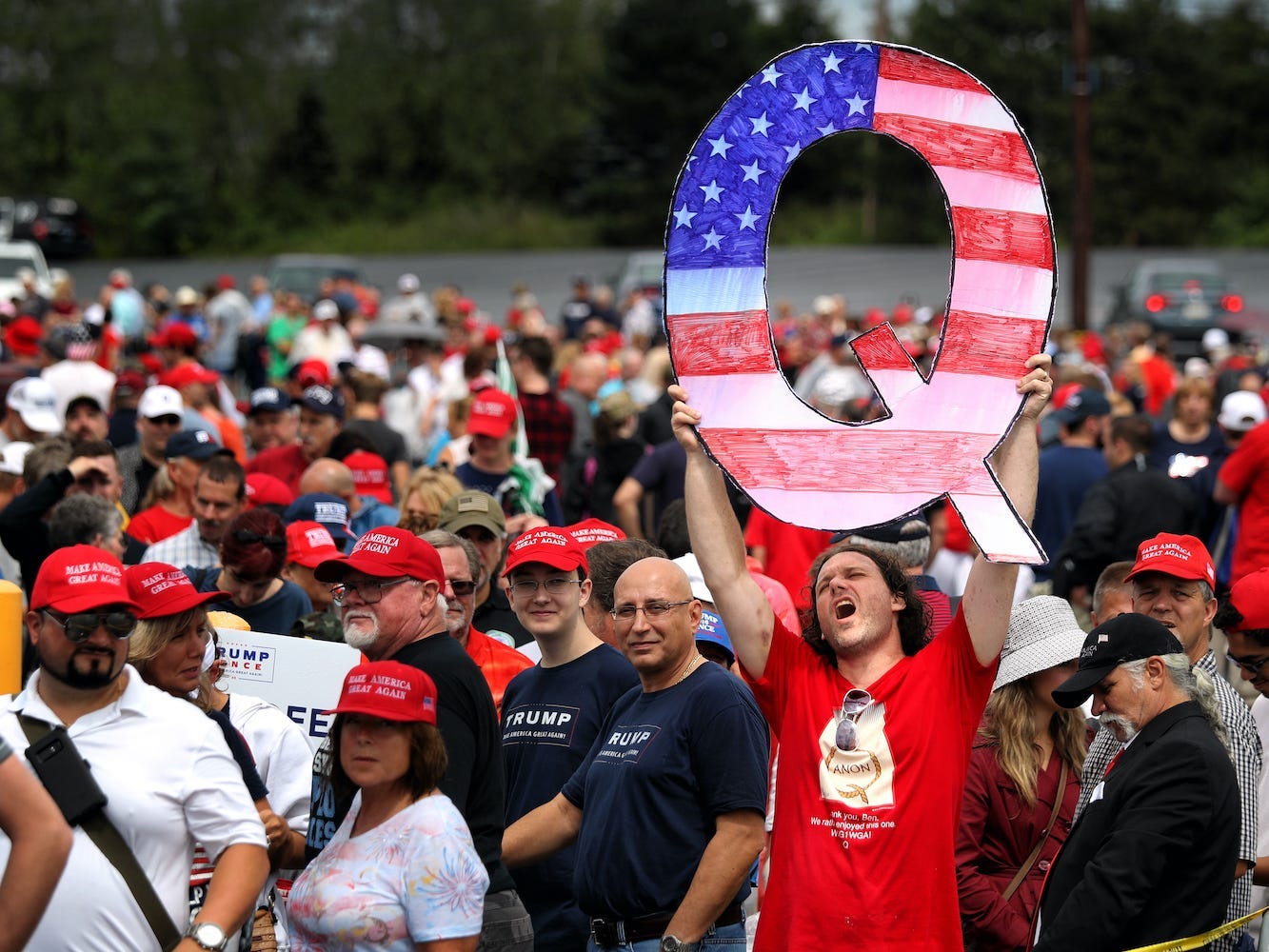 Trump supporter holds up a QAnon sign at rally.