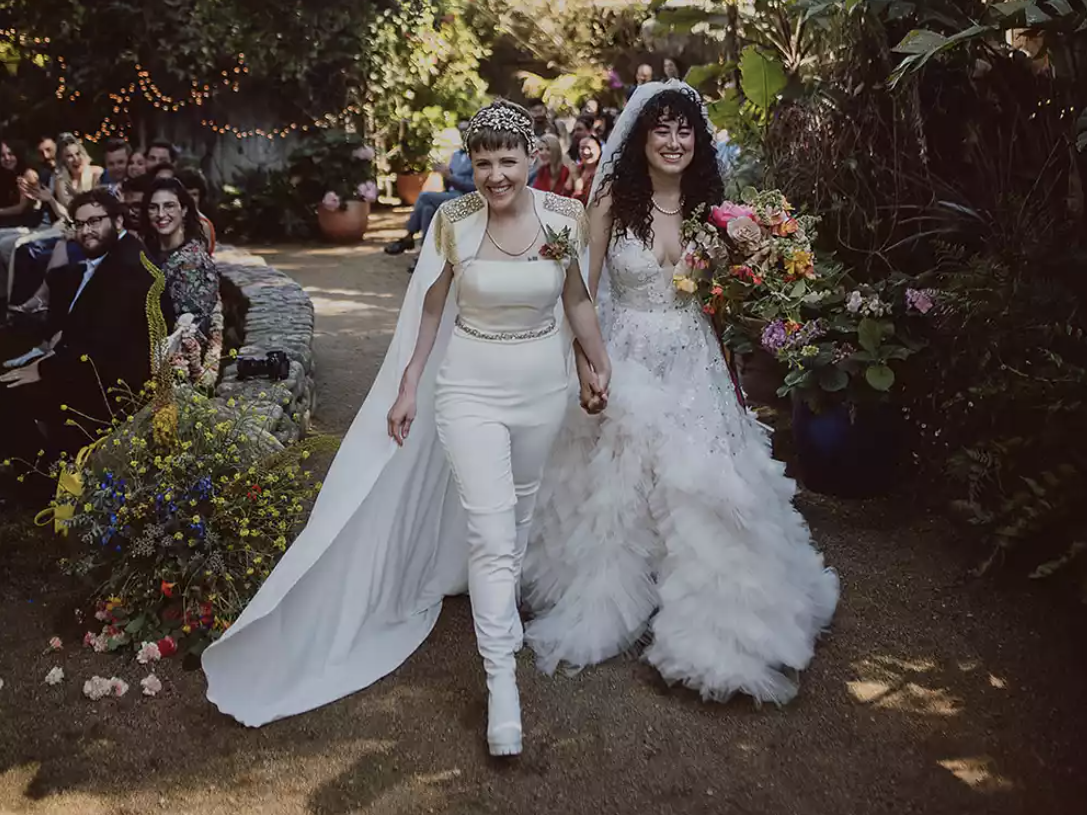 Hannah Hart and Ella Mielniczenko walk down the aisle after getting married.