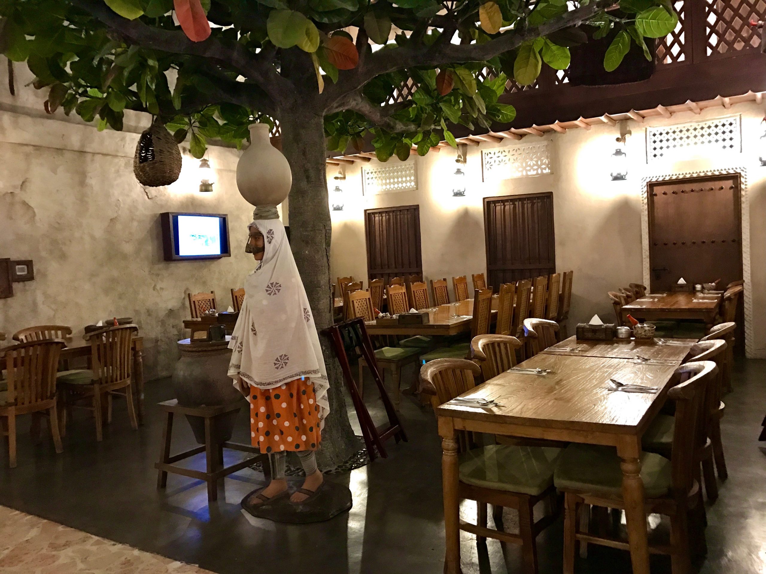 interior shot of the dining room at Al Fanar Restaurant & Café in Dubai featuring a large tree at the center