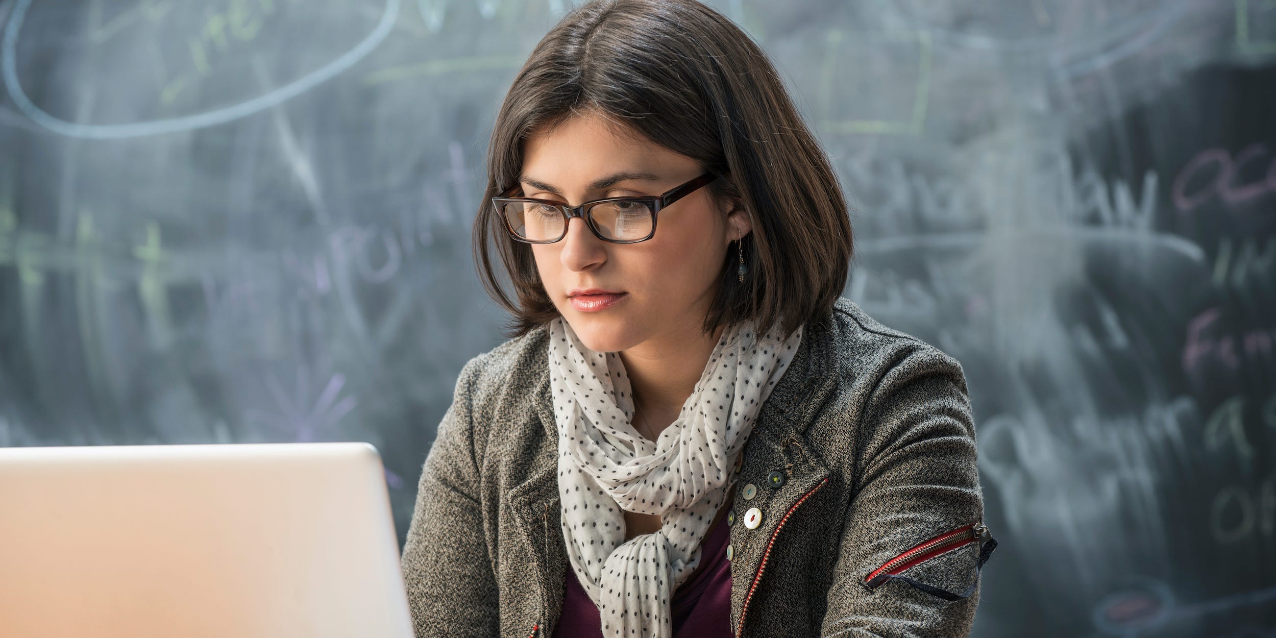 teacher student in classroom on laptop typing