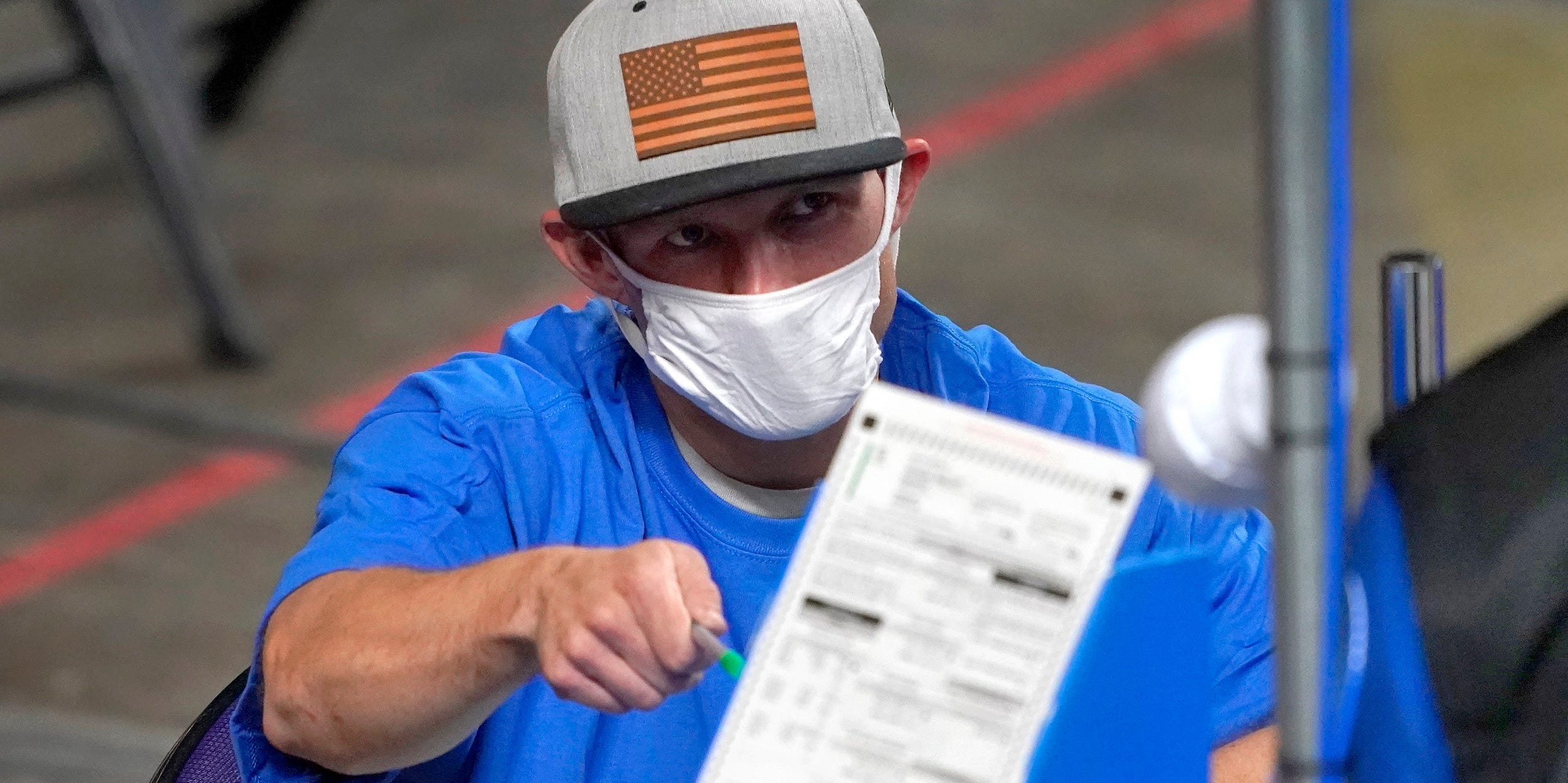 In this May 6, 2021 file photo, Maricopa County ballots cast in the 2020 general election are examined and recounted by contractors working for Florida-based company, Cyber Ninjas at Veterans Memorial Coliseum in Phoenix.