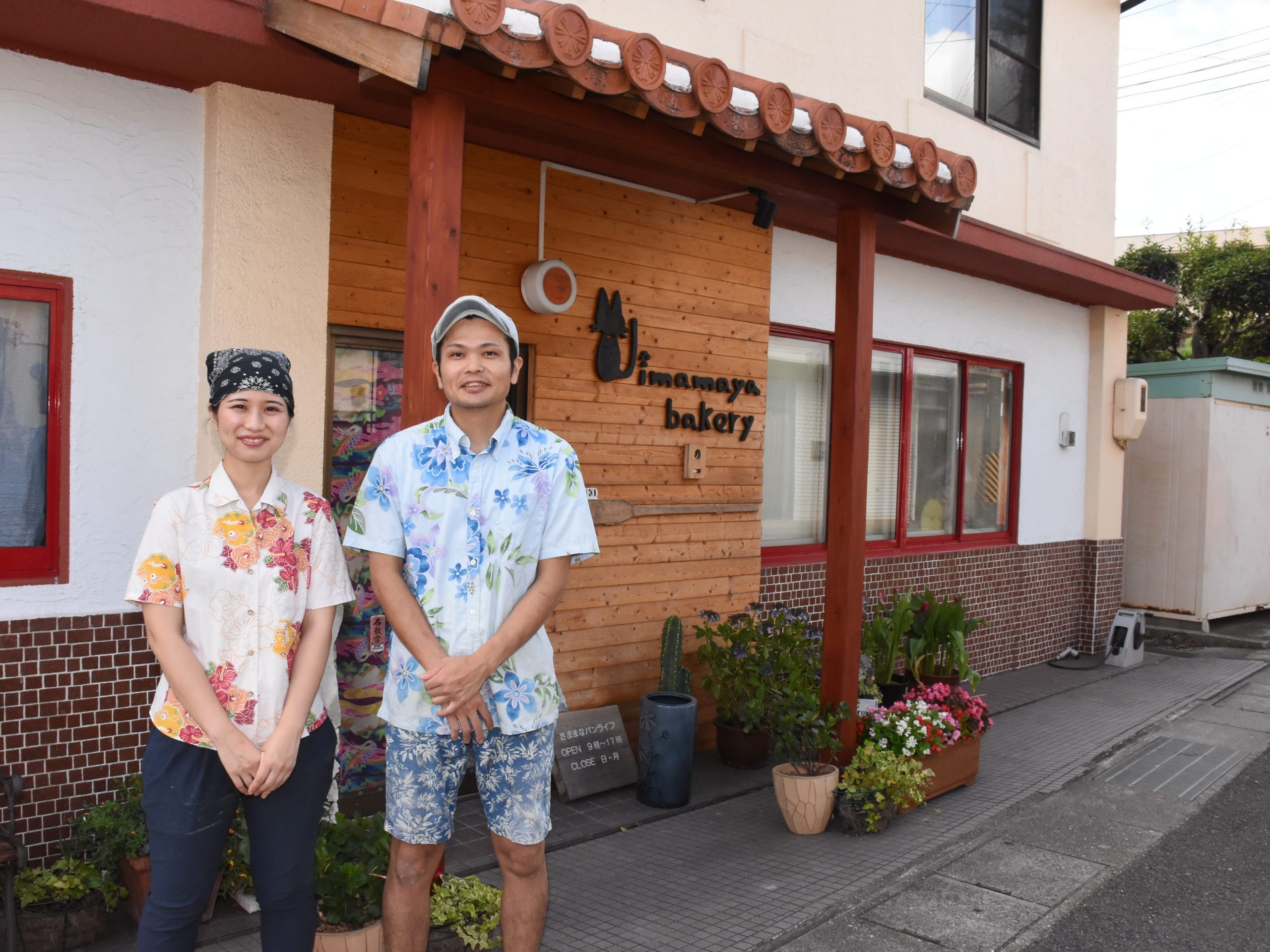 Yuichi Nomura and his wife smiling in front of the bakery they run in Wakiyama, Japan.
