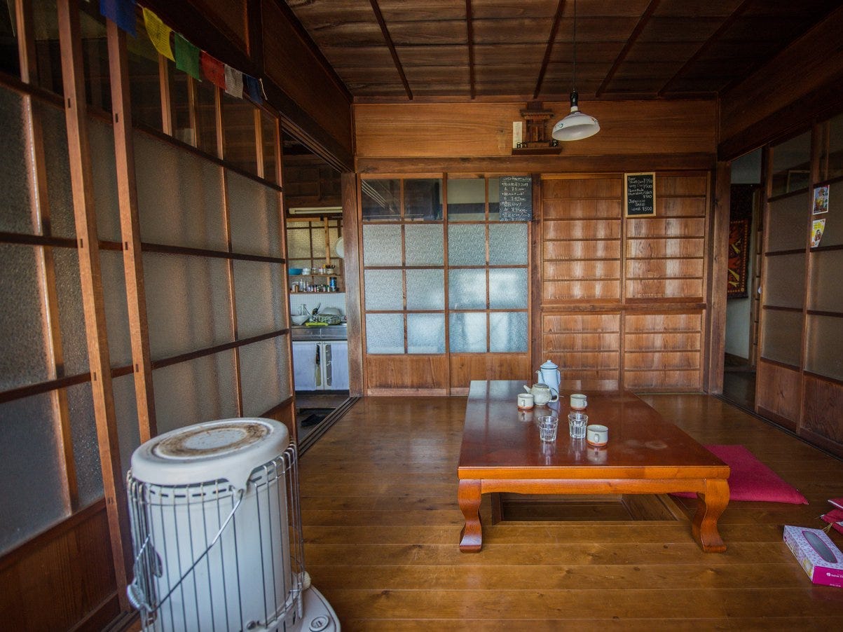 The interior of the akiya shows wood paneling and a clean, minimal design