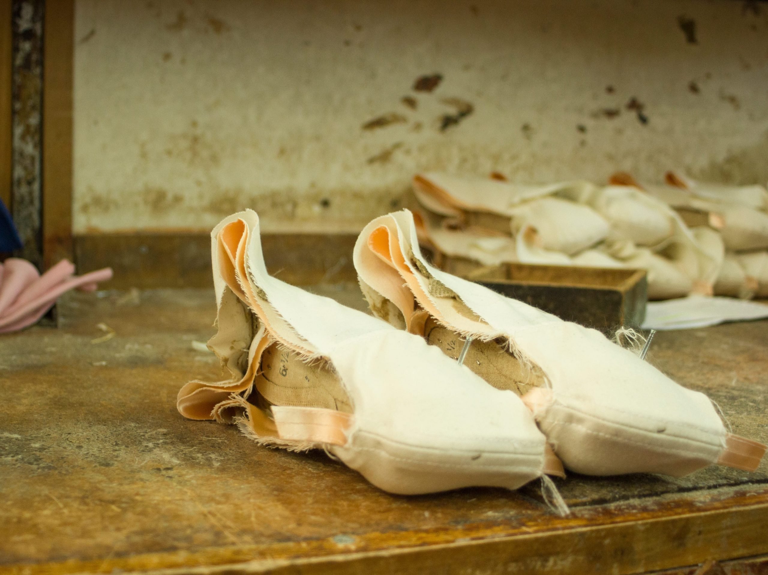 pink pointe shoes laying on a table