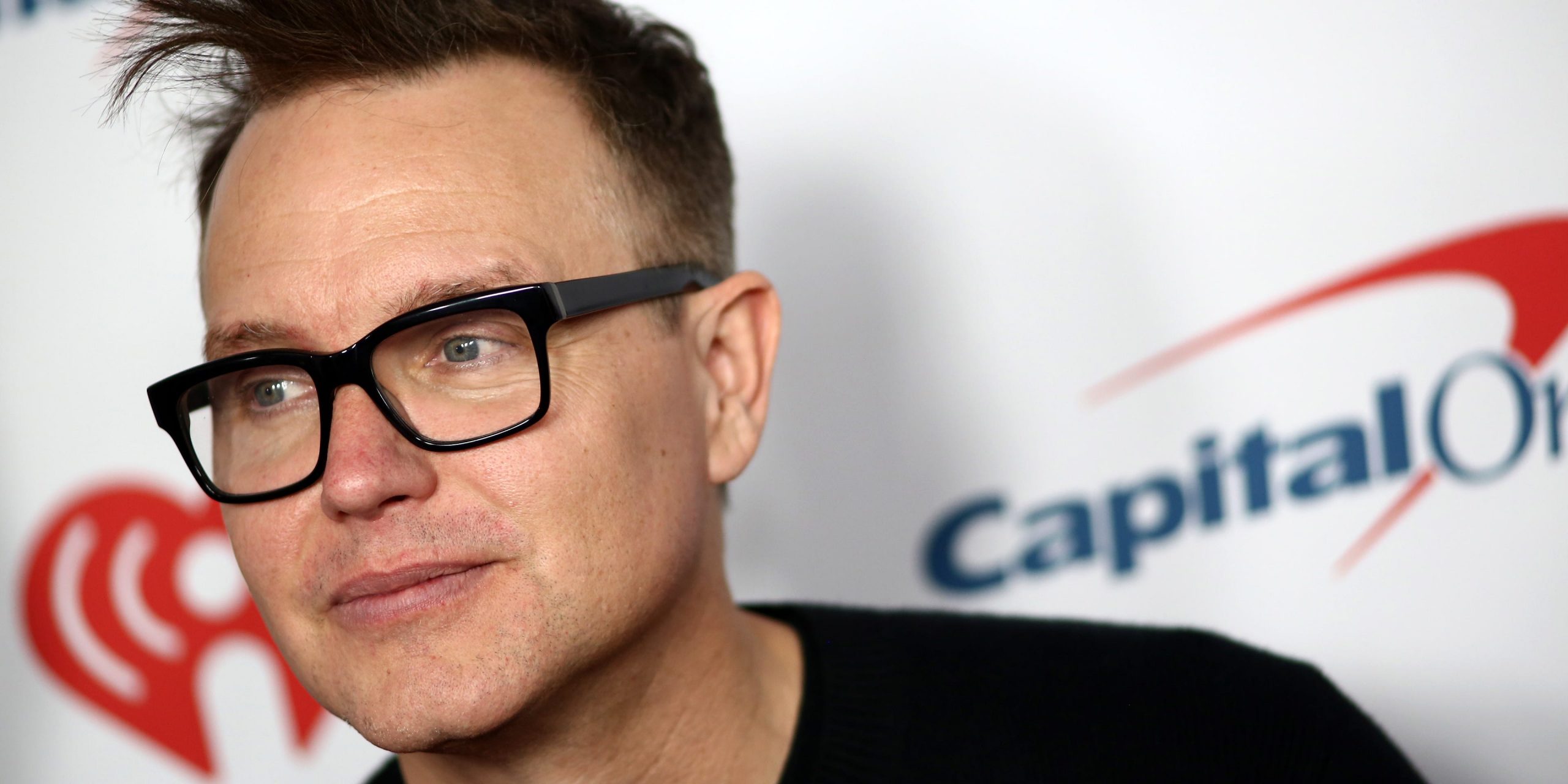 Close up of Mark Hoppus wearing black, thick-rimmed glasses.