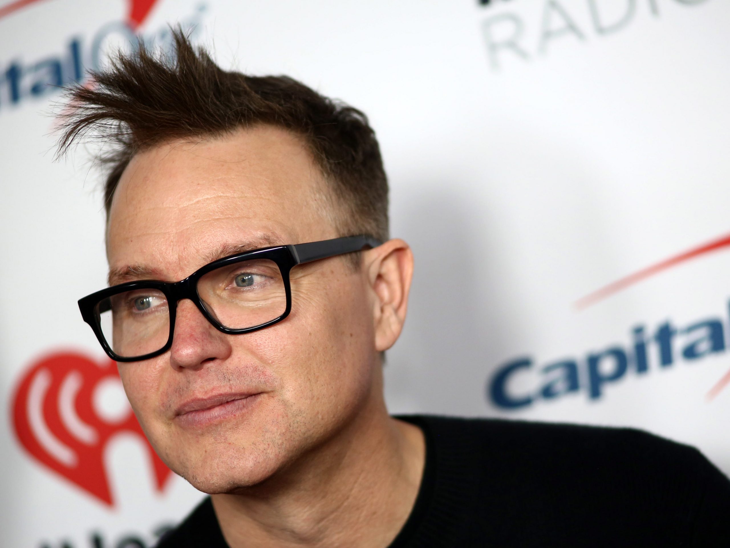 Close up of Mark Hoppus wearing black, thick-rimmed glasses.