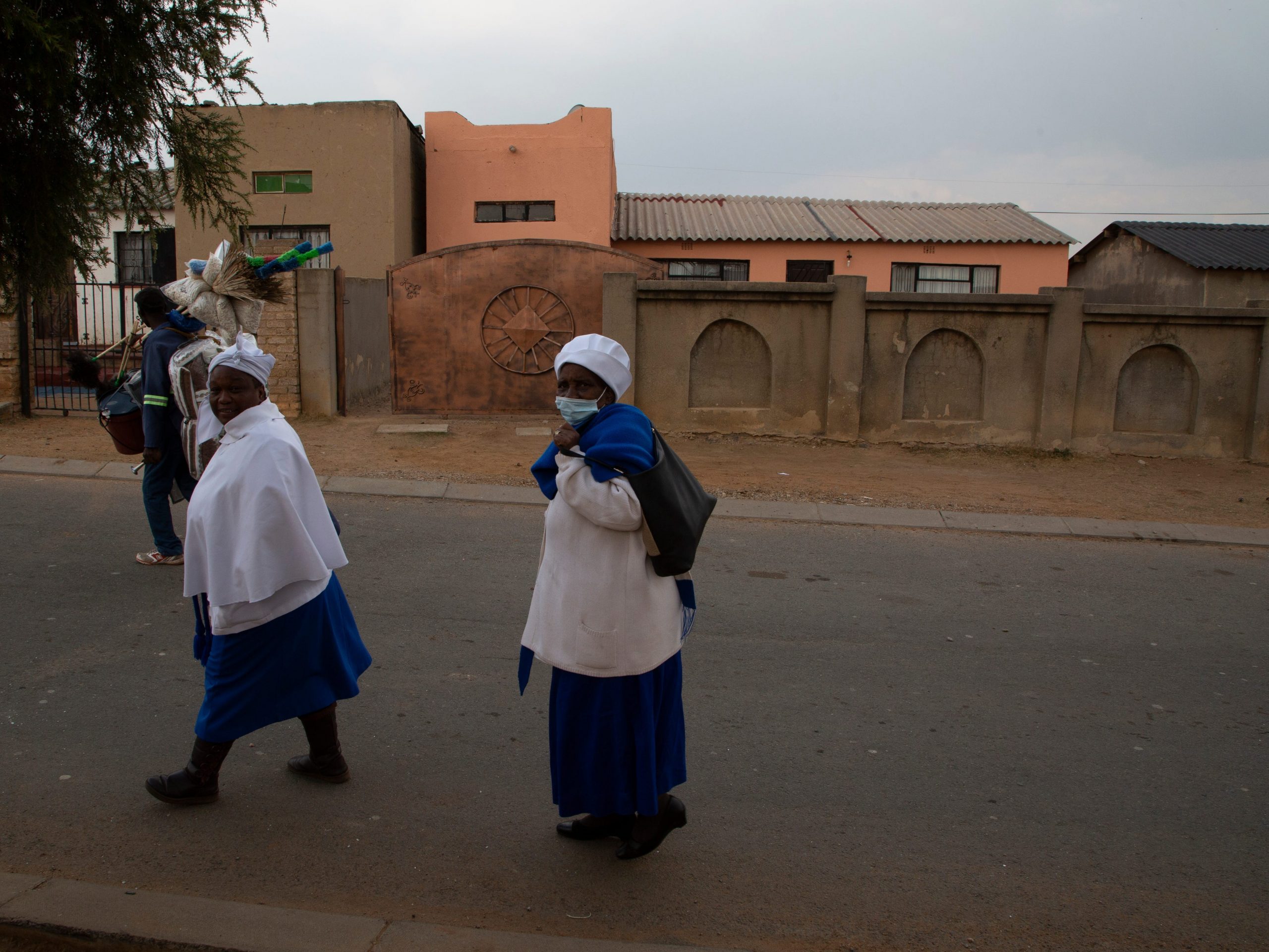 Women walk outside the home of Gosiame Sithole