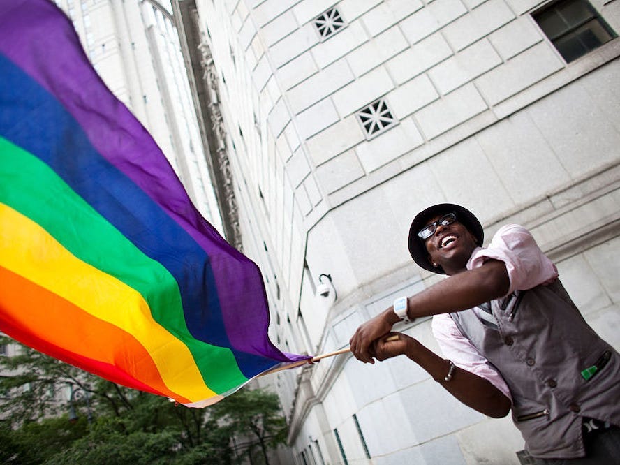 Man waves rainbow flag on first day of legalized same-sex marriage in New York.