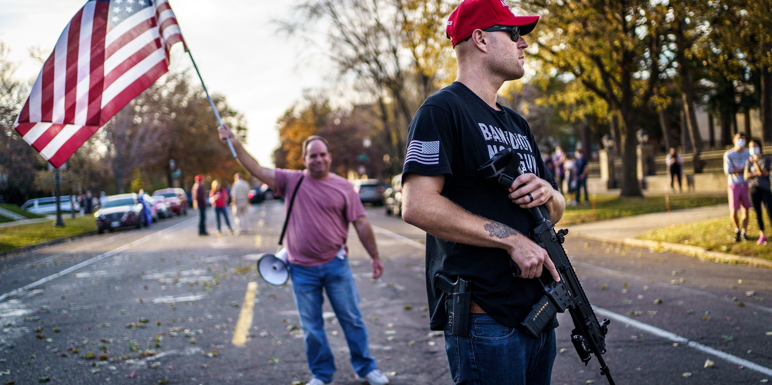 A supporter of US President Donald Trump keeps a hand on his gun during a "Stop the Steal rally" in front of the residence of Minnesota Governor Tim Walz in St Paul, Minnesota, on November 7, 2020.