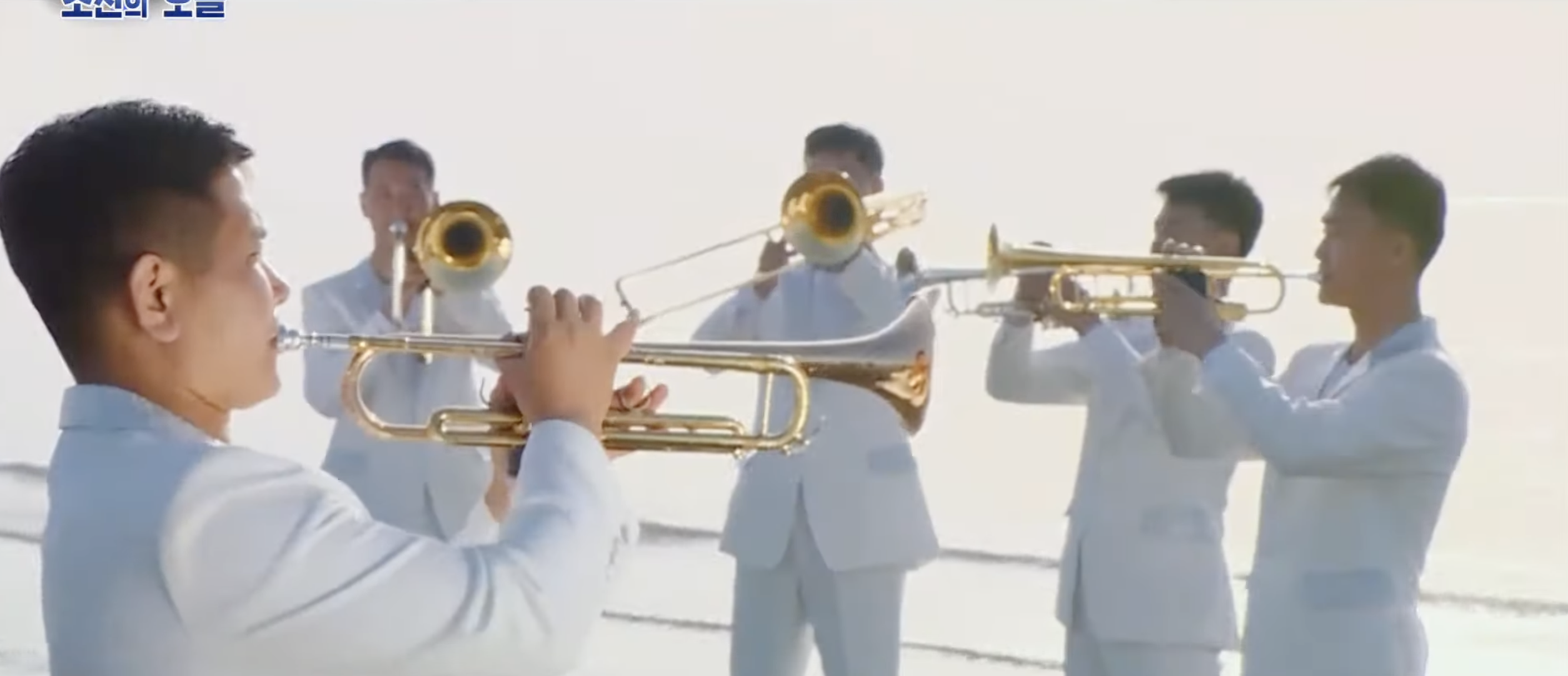 North Korean band playing many horns on the beach