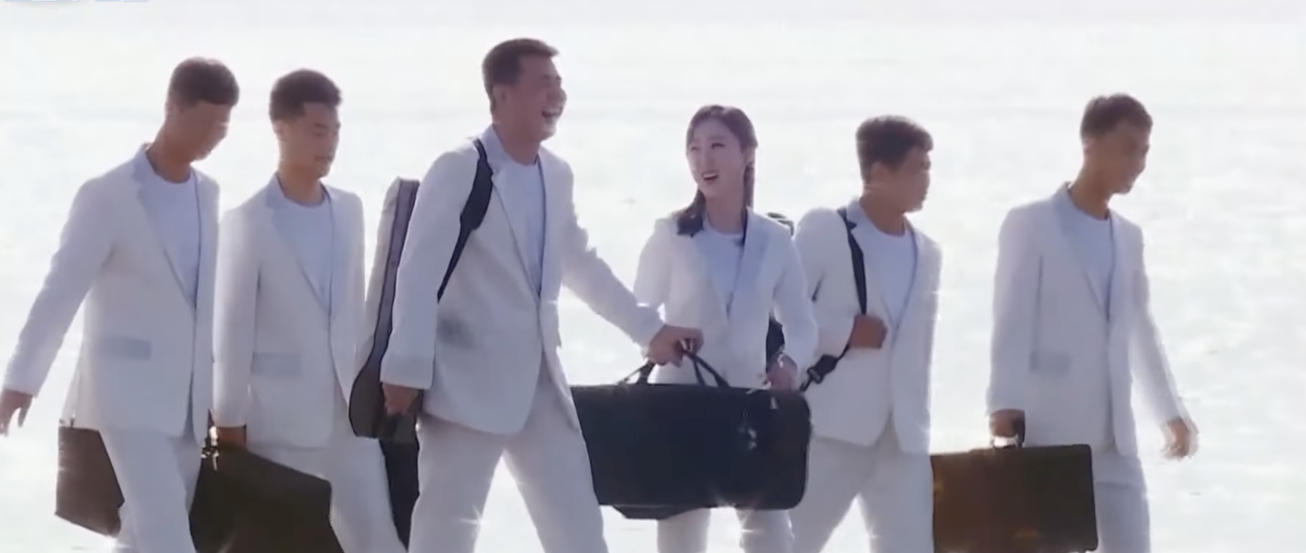 Group of musicians in white suits at the beach