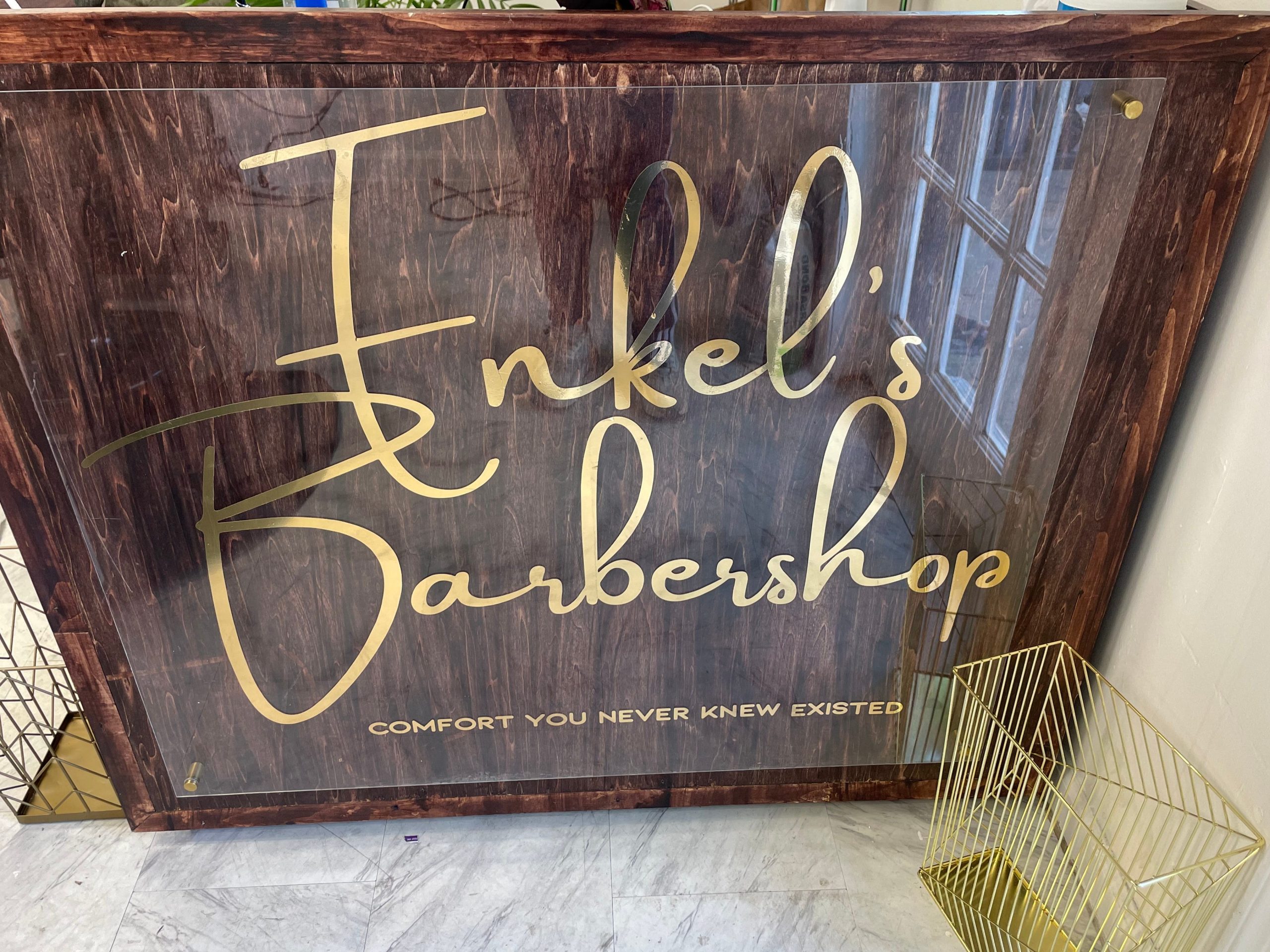 A counter at Enkel's Barbershop in Brooklyn displays the shop's logo.