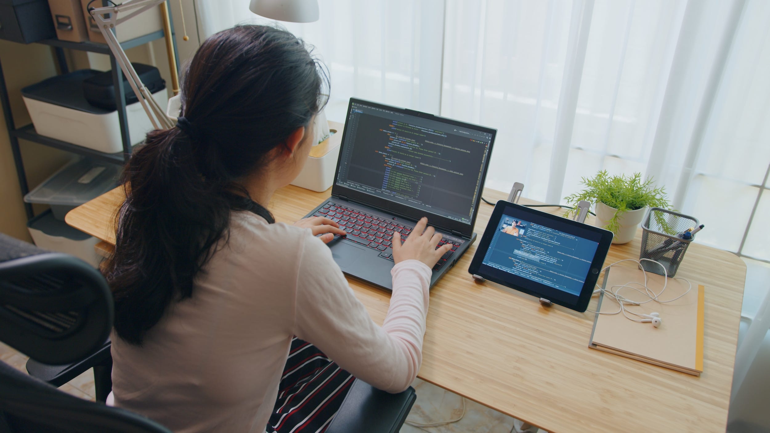 software developer coding on computer at desk at home