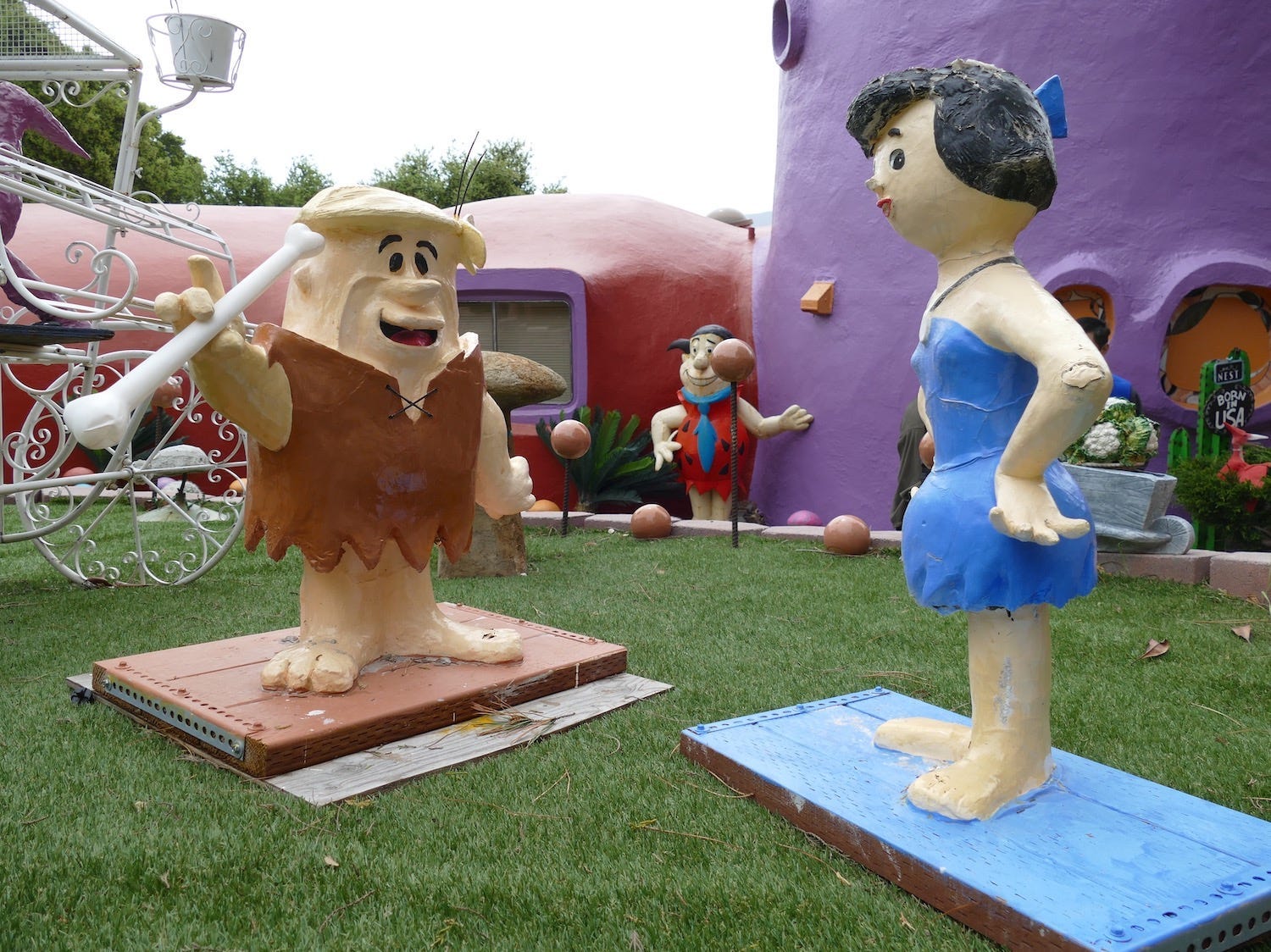 Statues of Fred Flintstone and Betty Ruble outside of the Flintstone House