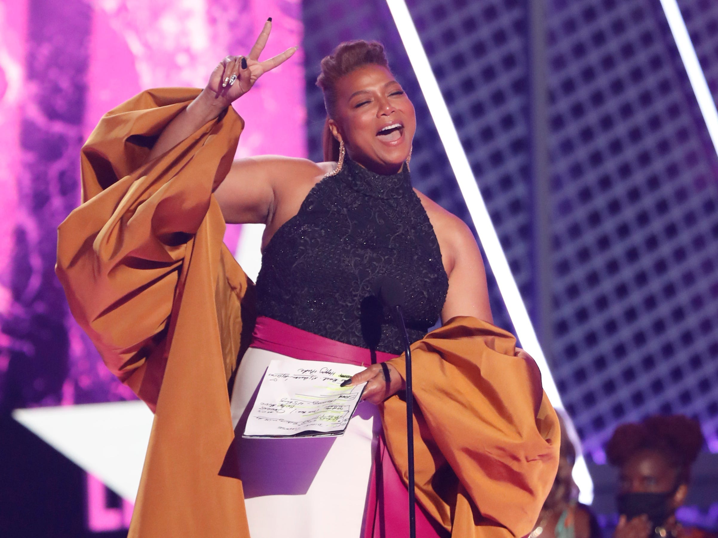 Queen Latifah putting up a peace sign