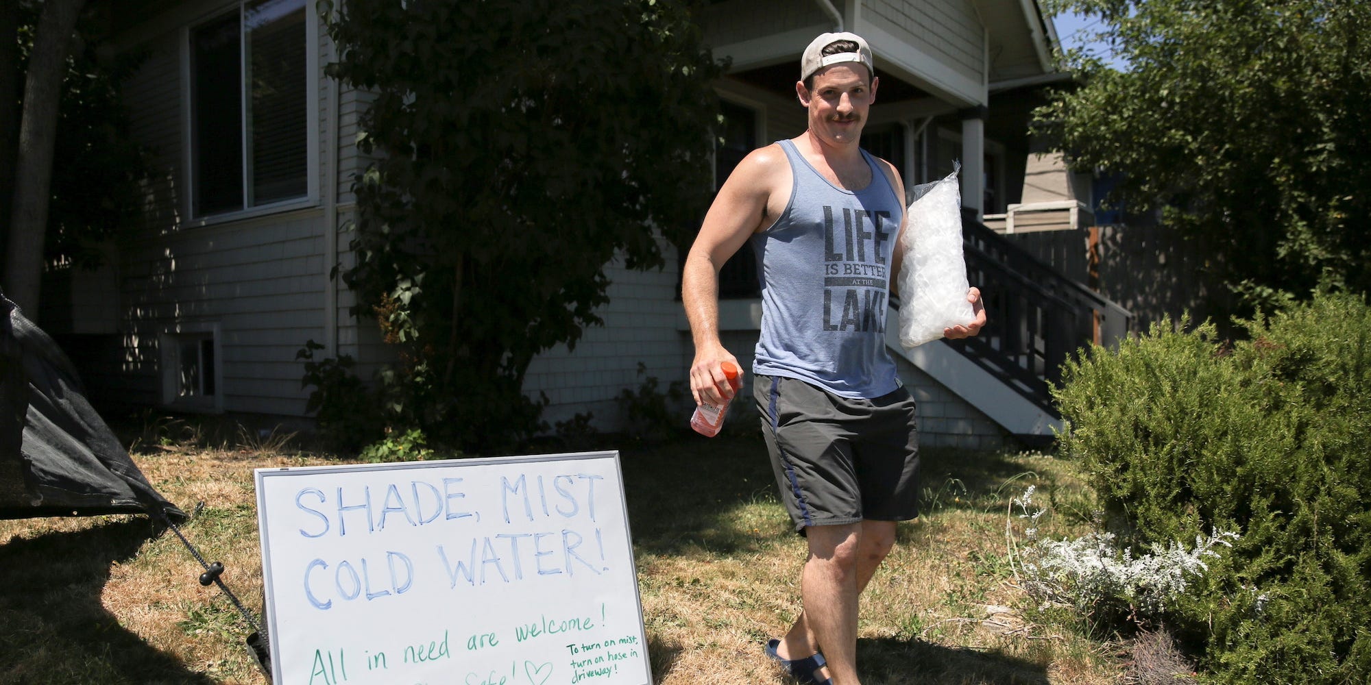 Mark Aldham, 34, brings a bag of ice out to his homemade cooling-off station and mist system that he and his partner set up in their front yard for people, especially those without homes, to use during the scorching weather of a heatwave in Seattle, Washington, US June 28, 2021.