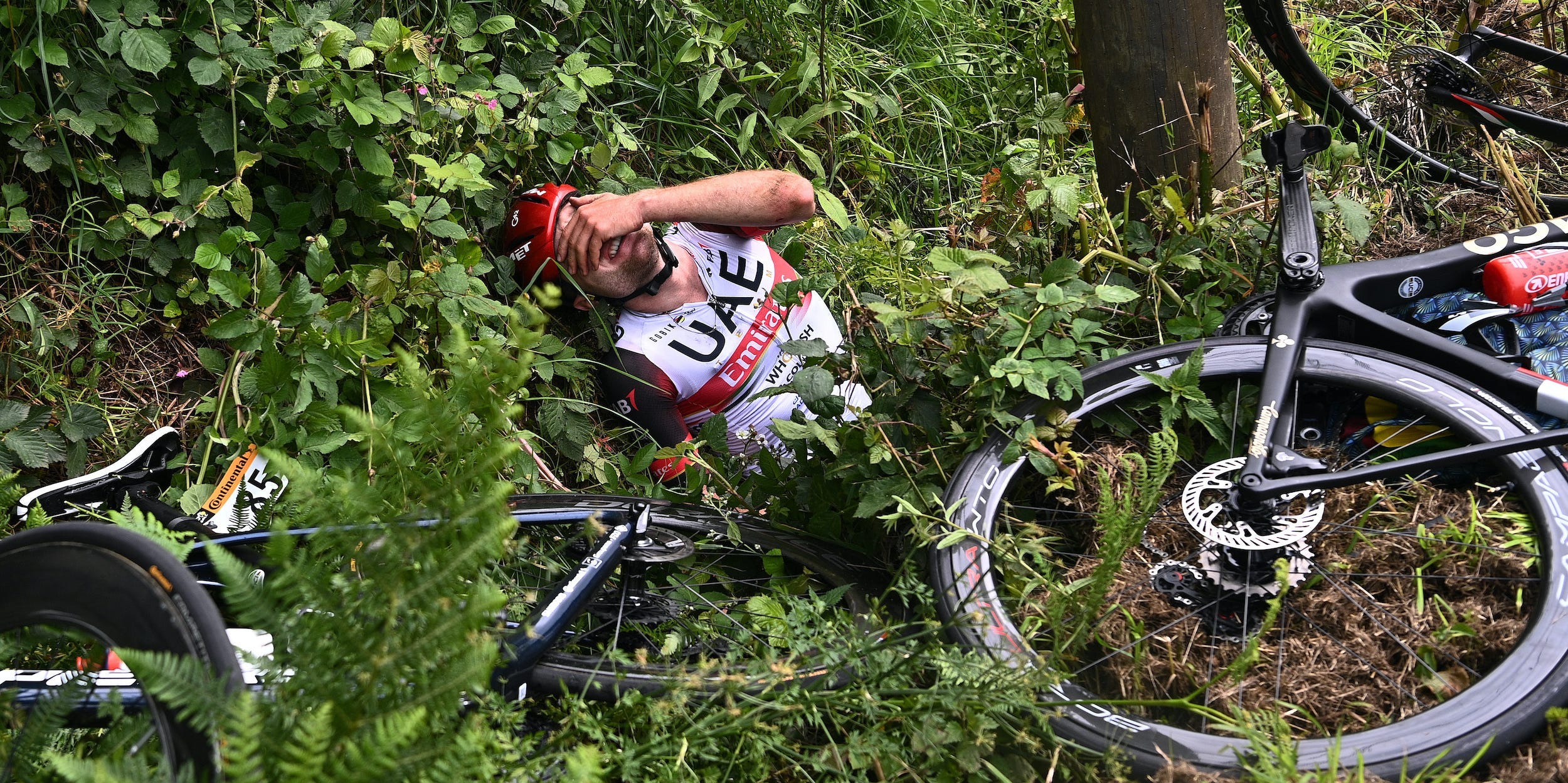 Tour de France rider March Hirschi lies in the bushes after Stage One horror crash