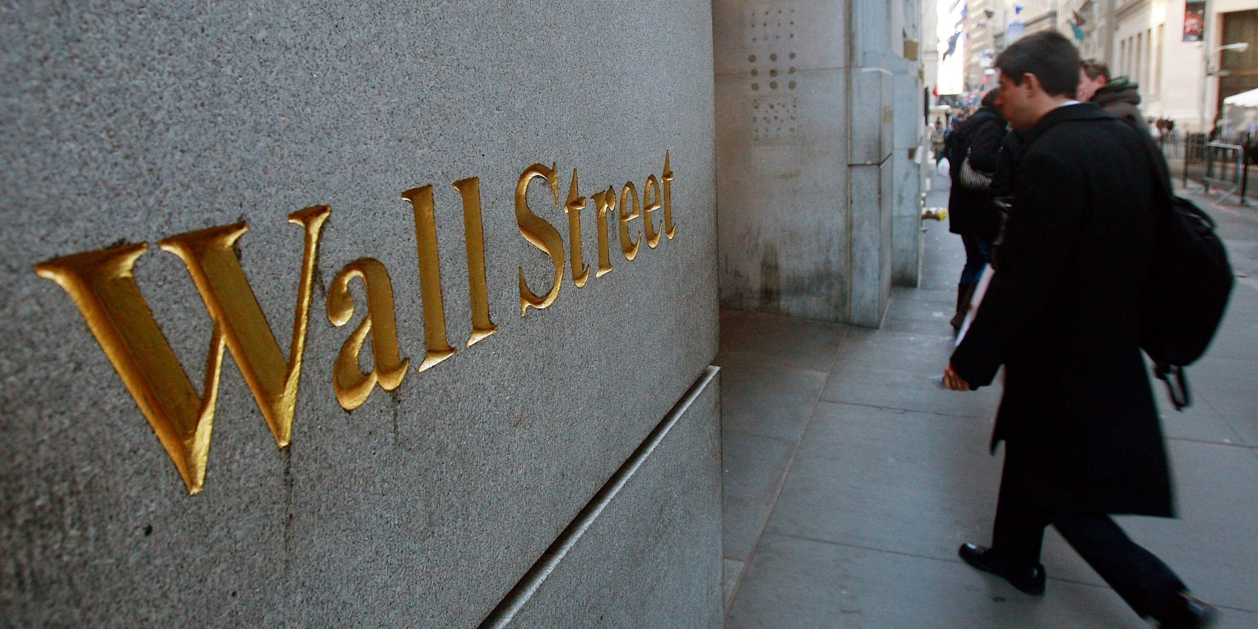 wall street man walking into building nyse stock exchange