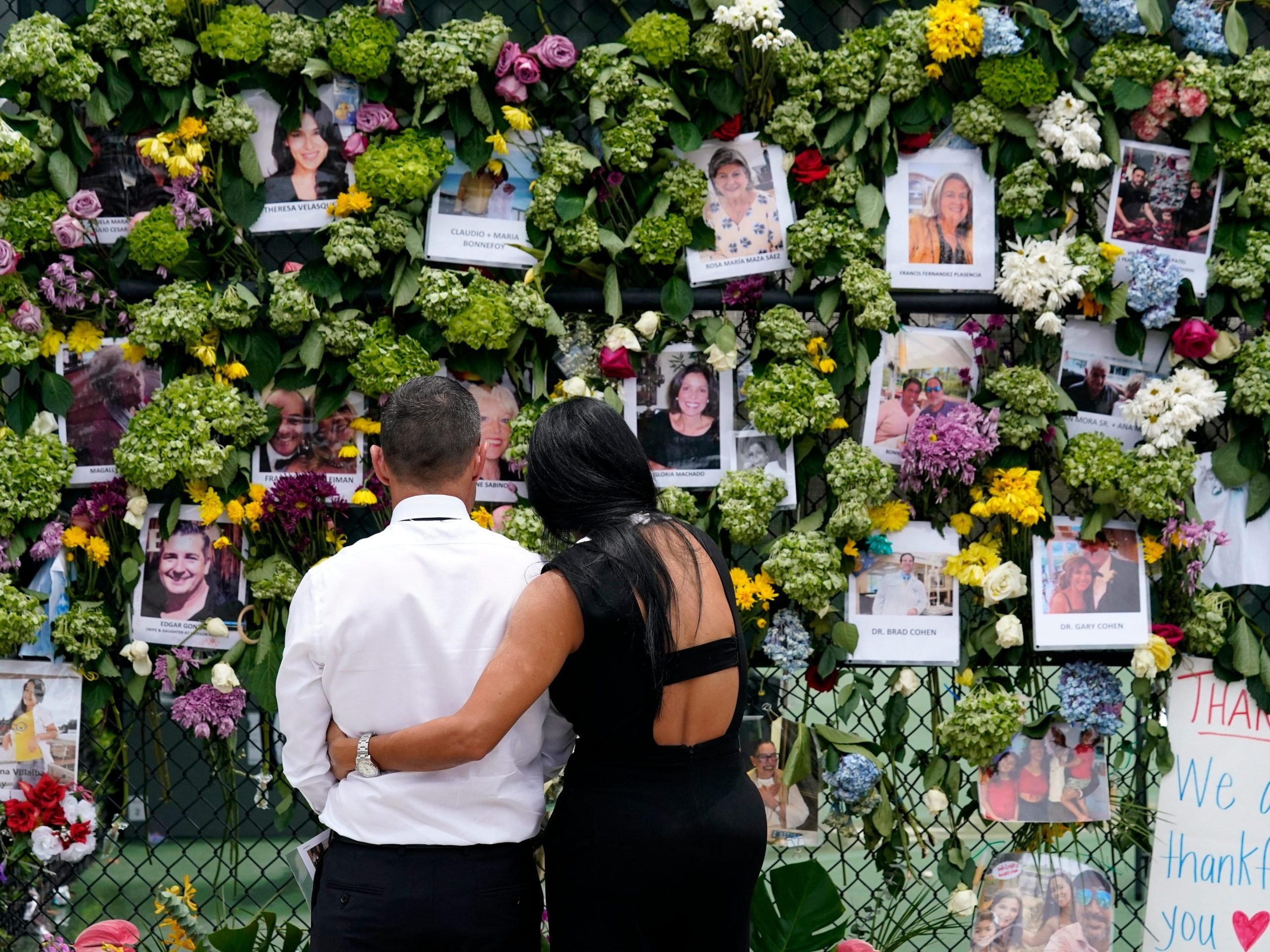 Mourners stand at a make-shift memorial outside St. Joseph Catholic Church near the collapsed Champlain Towers South condo building.