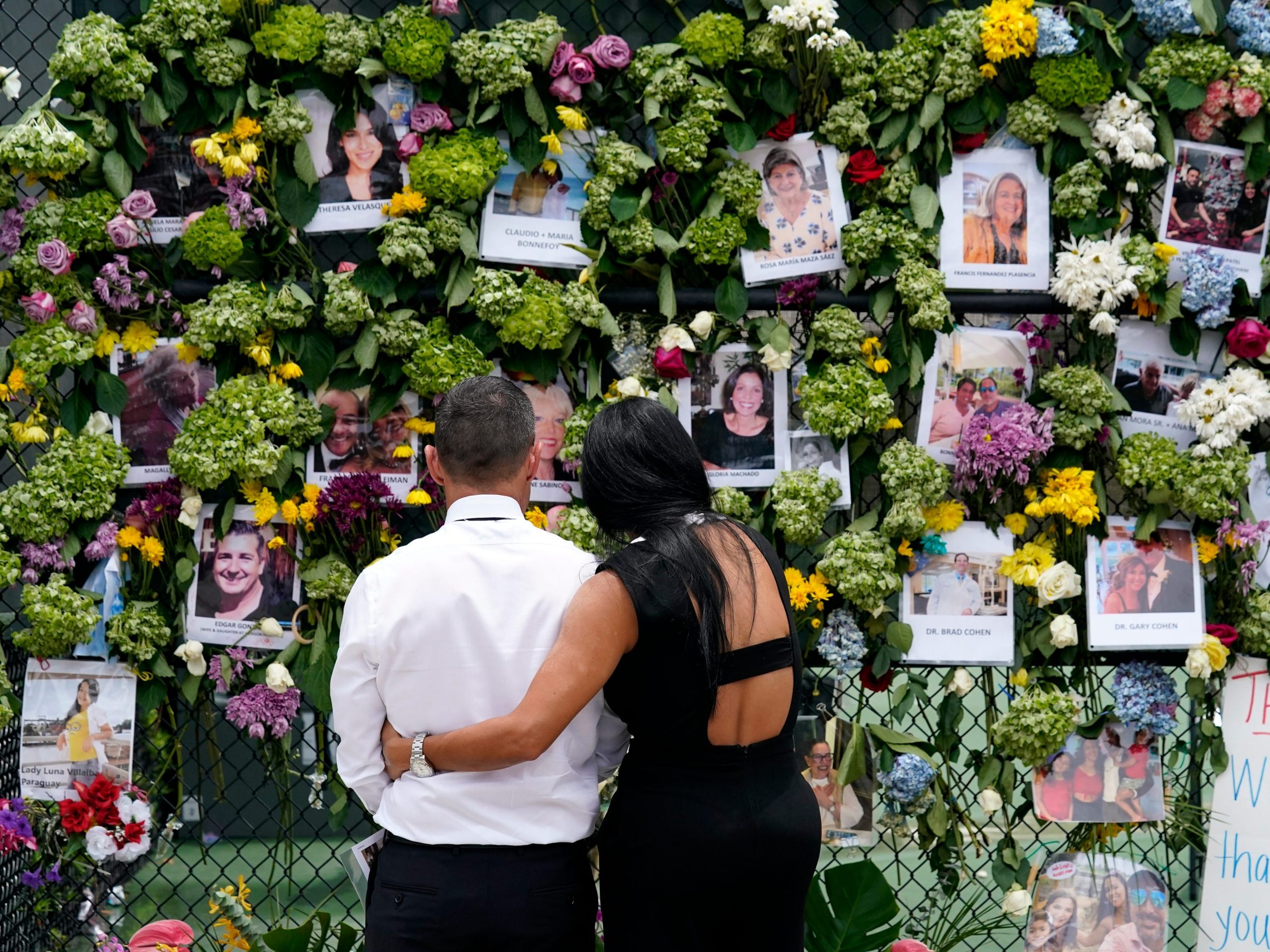 Mourners stand at a make-shift memorial outside St. Joseph Catholic Church near the collapsed Champlain Towers South condo building.