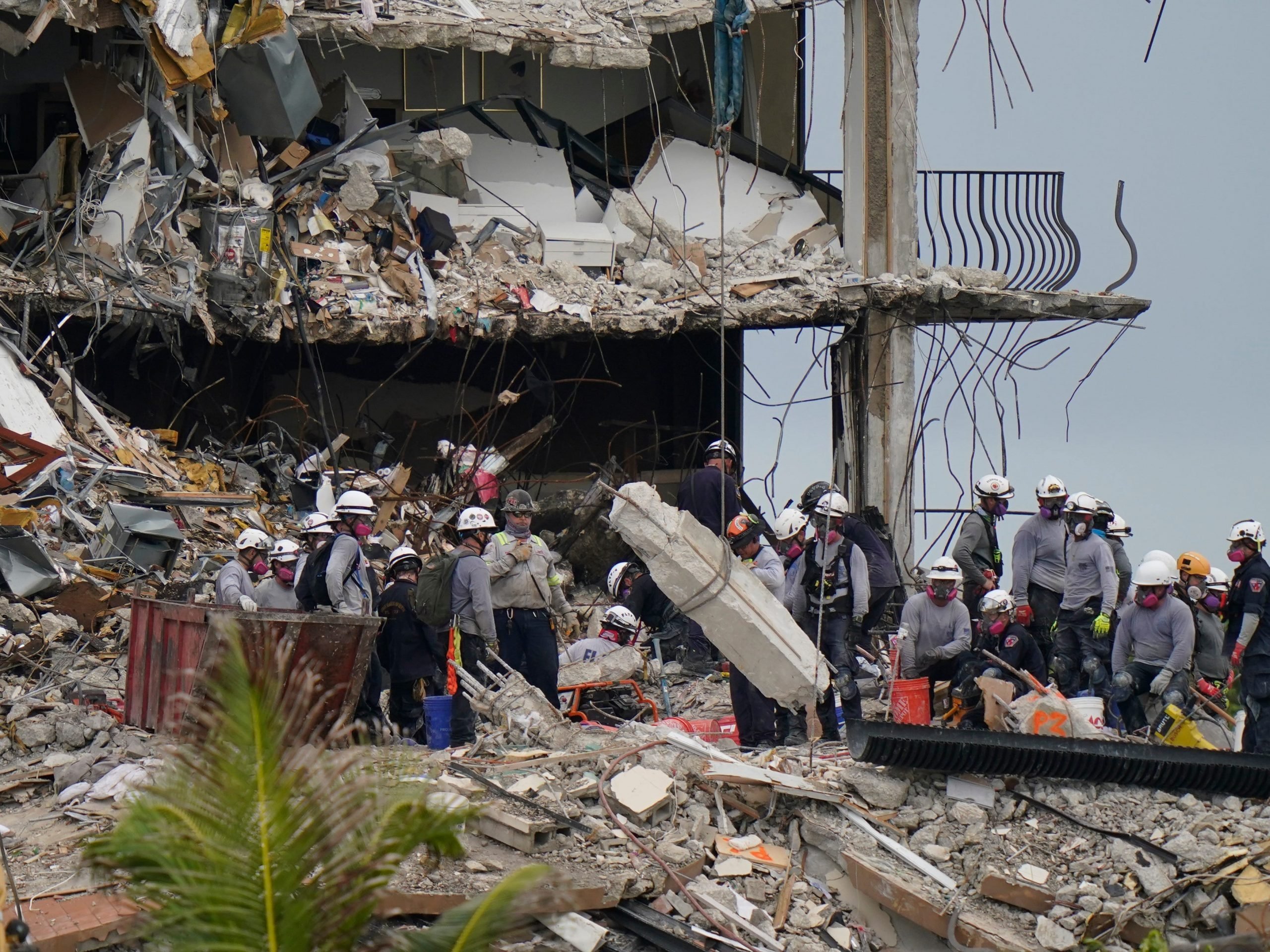 Search and rescue personnel work atop the rubble at the collapsed Champlain Towers South condo building.