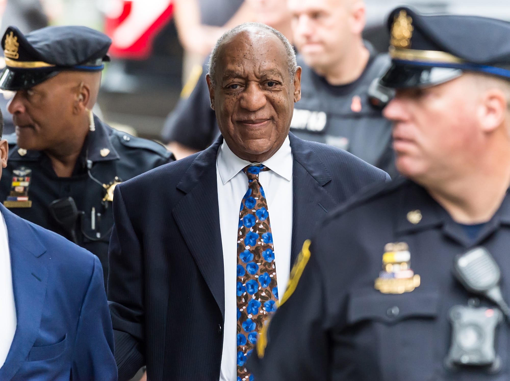 Bill Cosby surrounded by police.