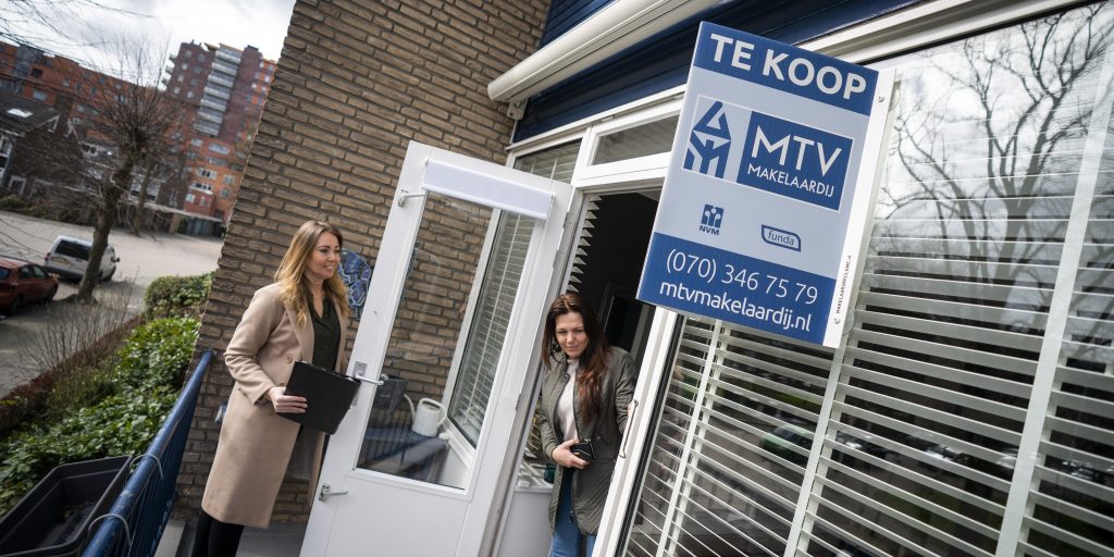 Een belangstellende wordt door een makelaar rondgeleid tijdens een bezichtiging aan een woning in Den Haag.
