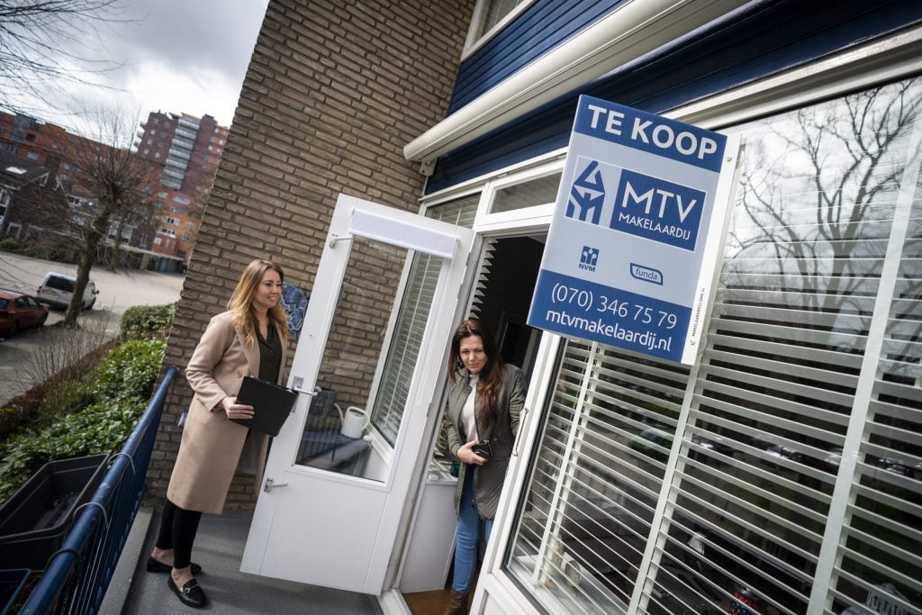 Een belangstellende wordt door een makelaar rondgeleid tijdens een bezichtiging aan een woning in Den Haag.