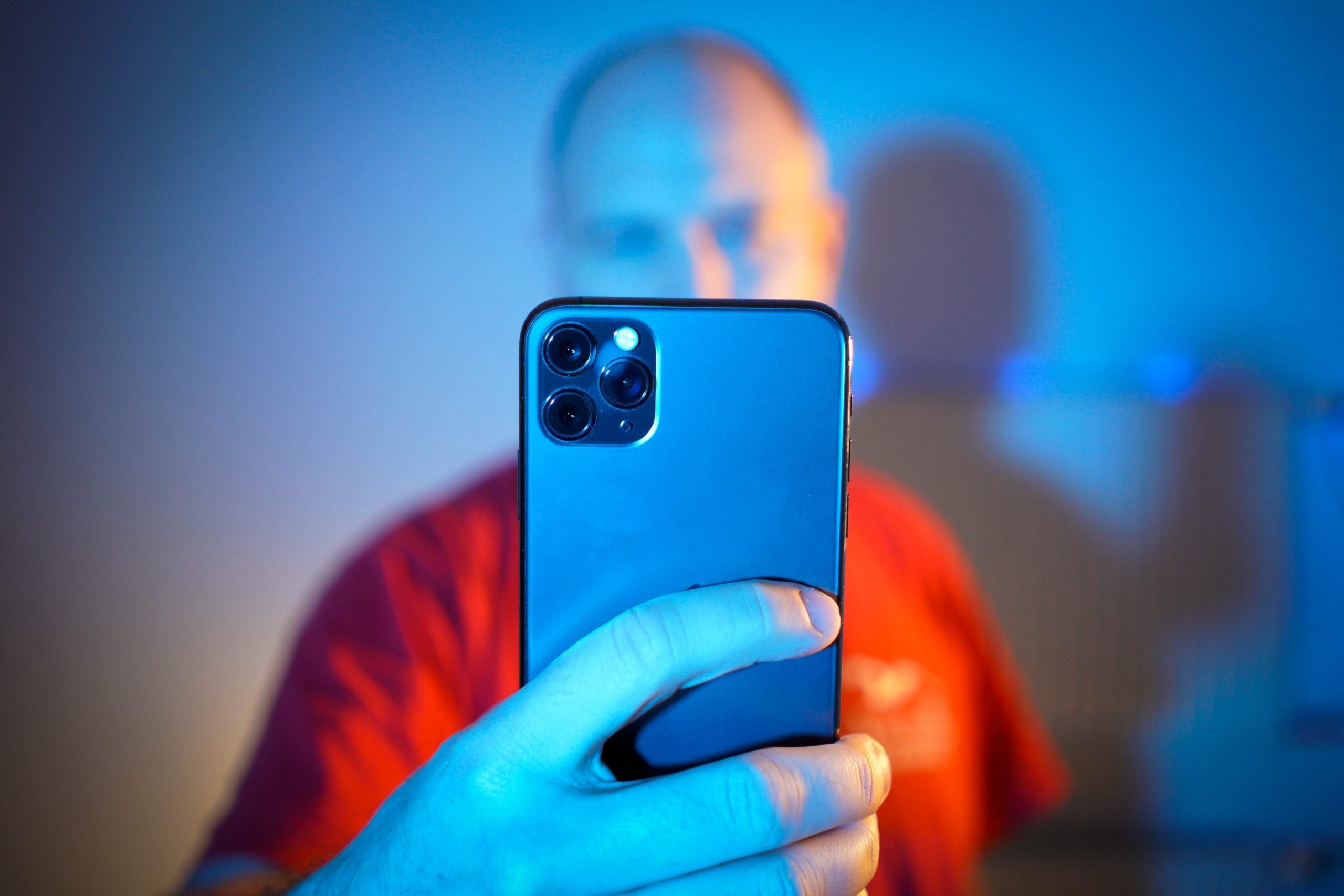 A stock image of a man seen looking at an Apple iPhone 11 Pro Max tin The Hague on March 2, 2020