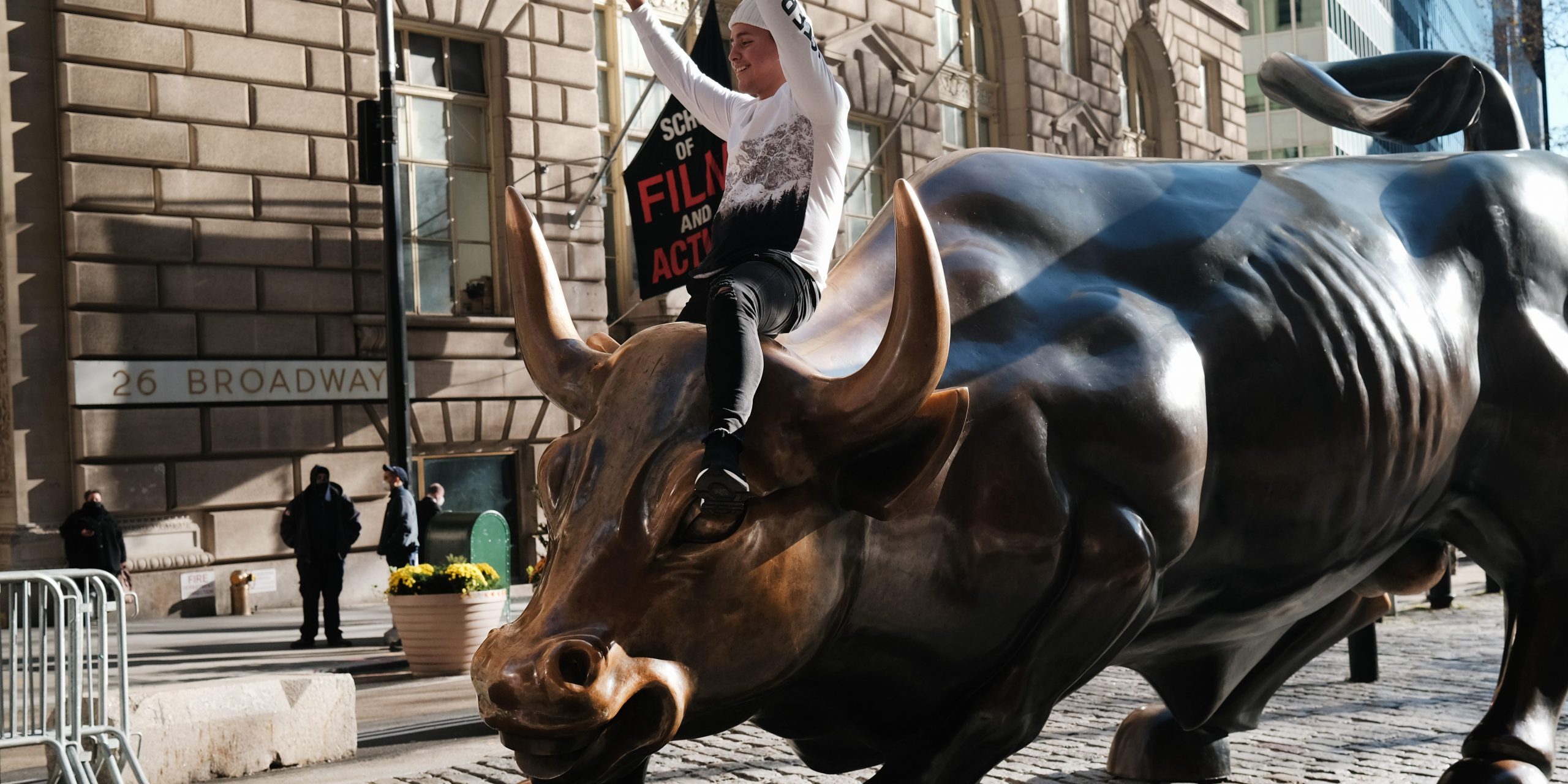 A man sits on the Wall street bull near the New York Stock Exchange