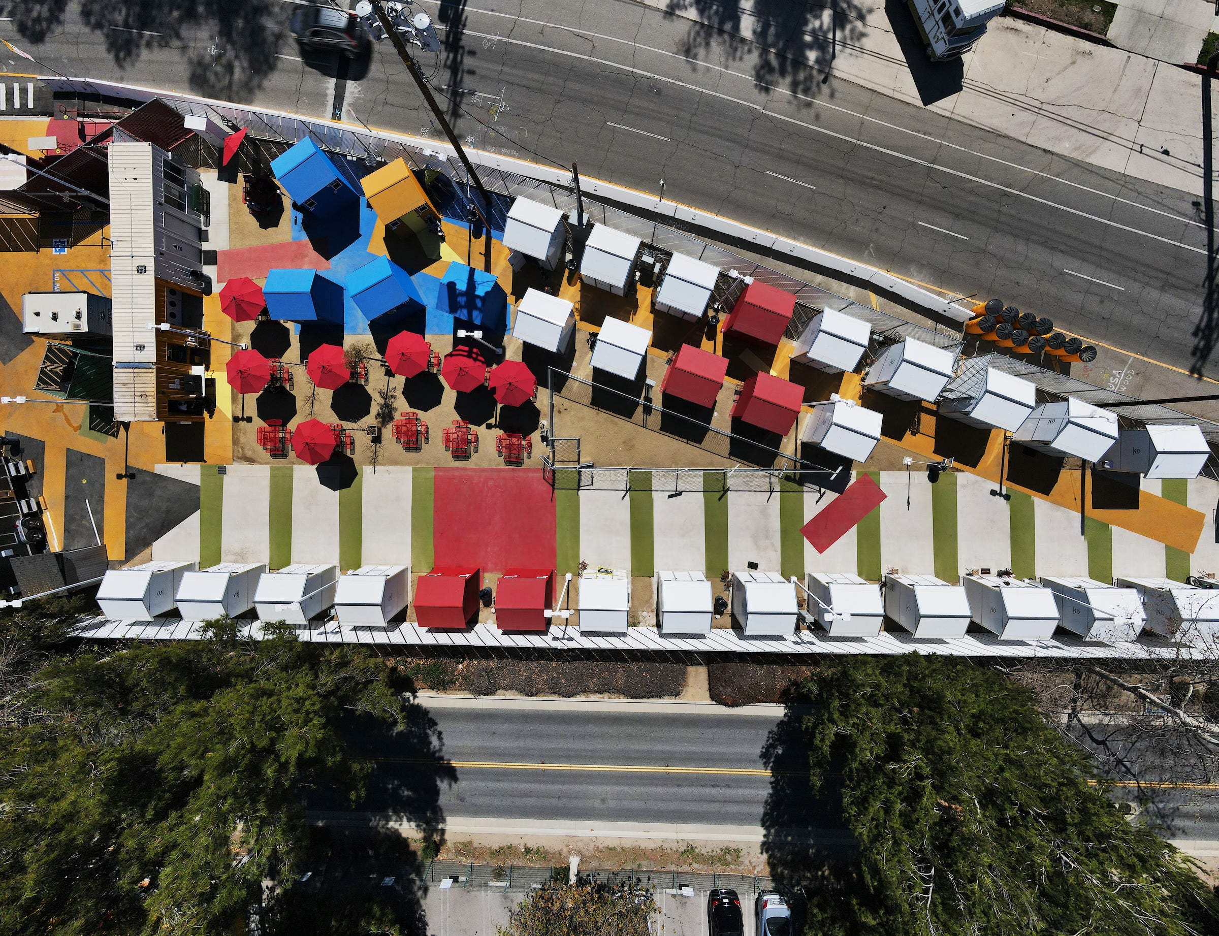 A sliver of land with colorful "tiny homes" sits at the intersection of two roadways.