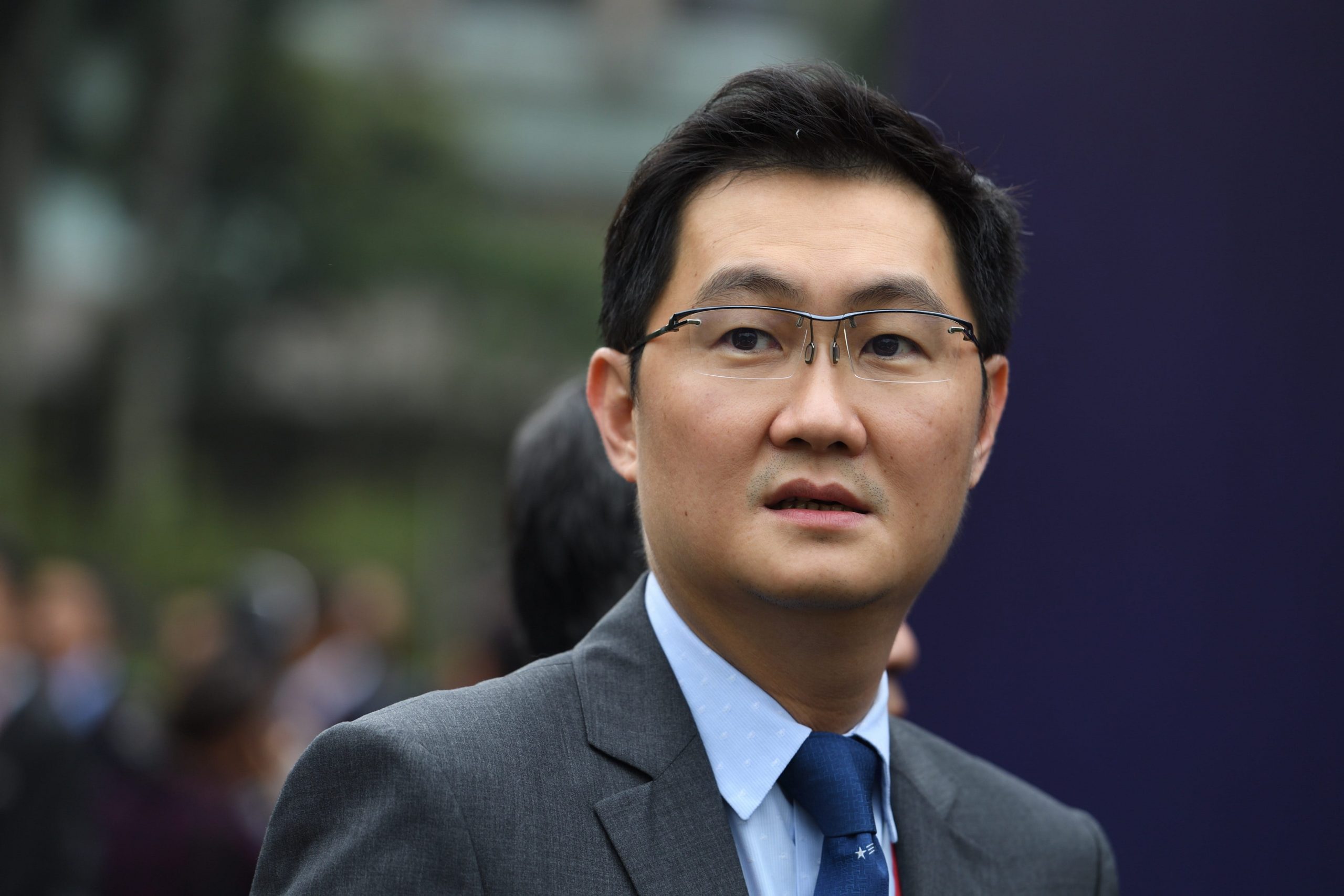 Ma Huateng, also known as Pony Ma, the CEO of Tencent looks into the distance while wearing a grey suit and blue tie.