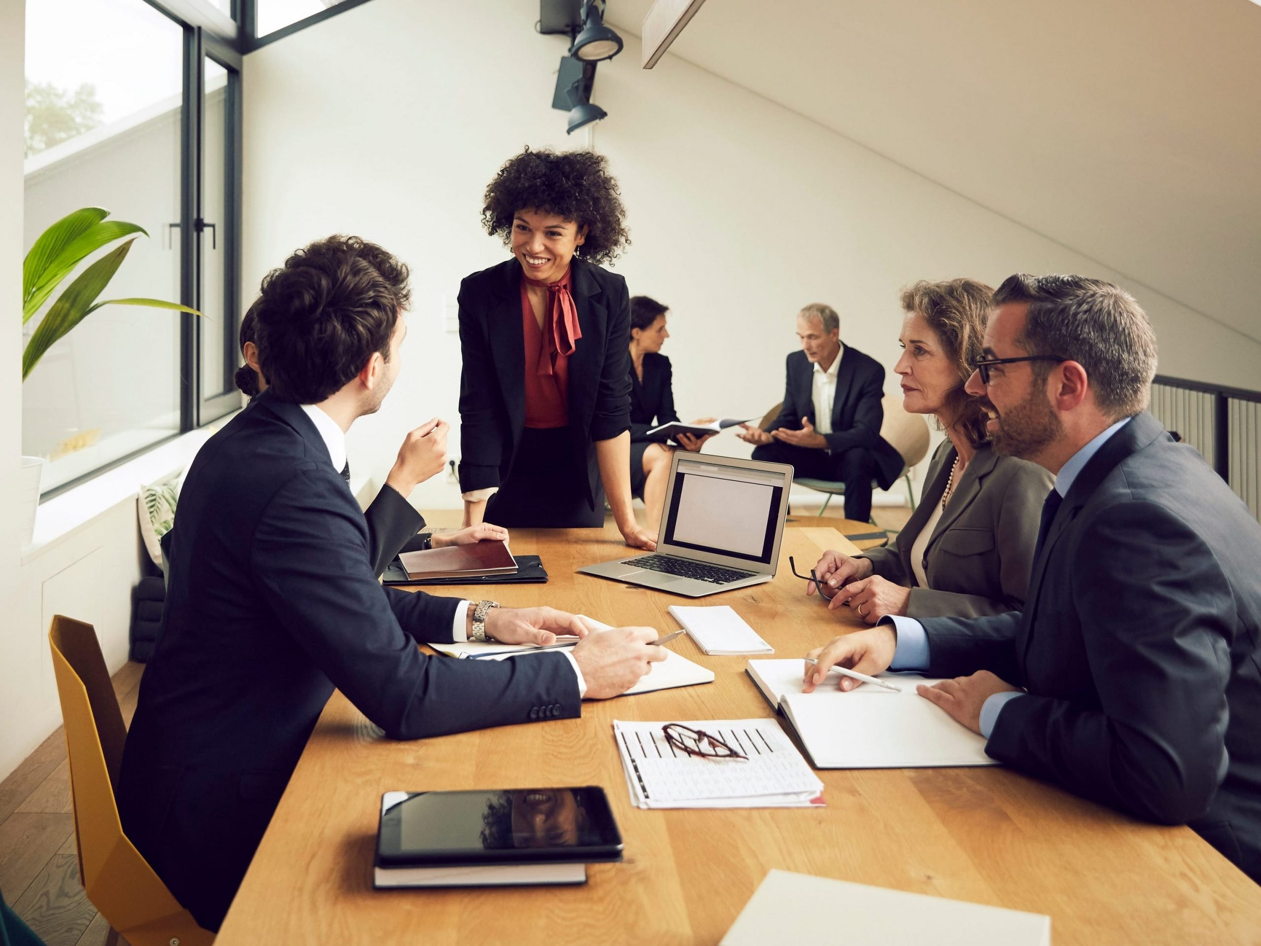 Black young businesswoman listening to discussion of lawyers during meeting at office