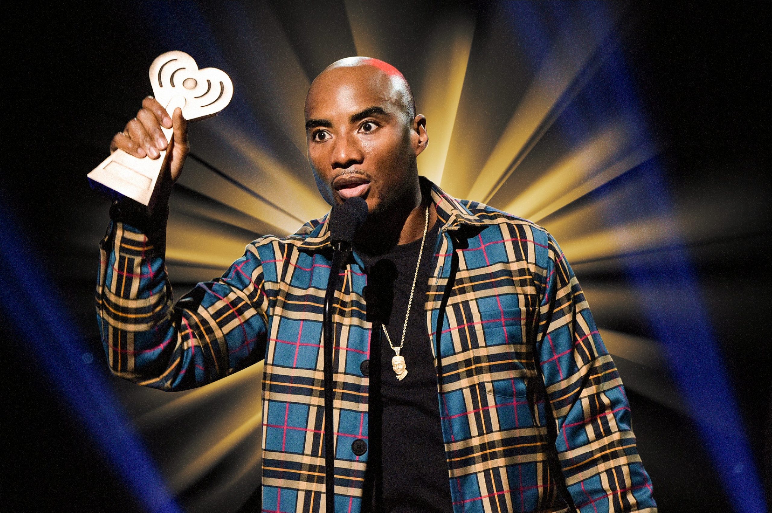 Charlamagne Tha God holding an award with a golden light radiating from behind him.