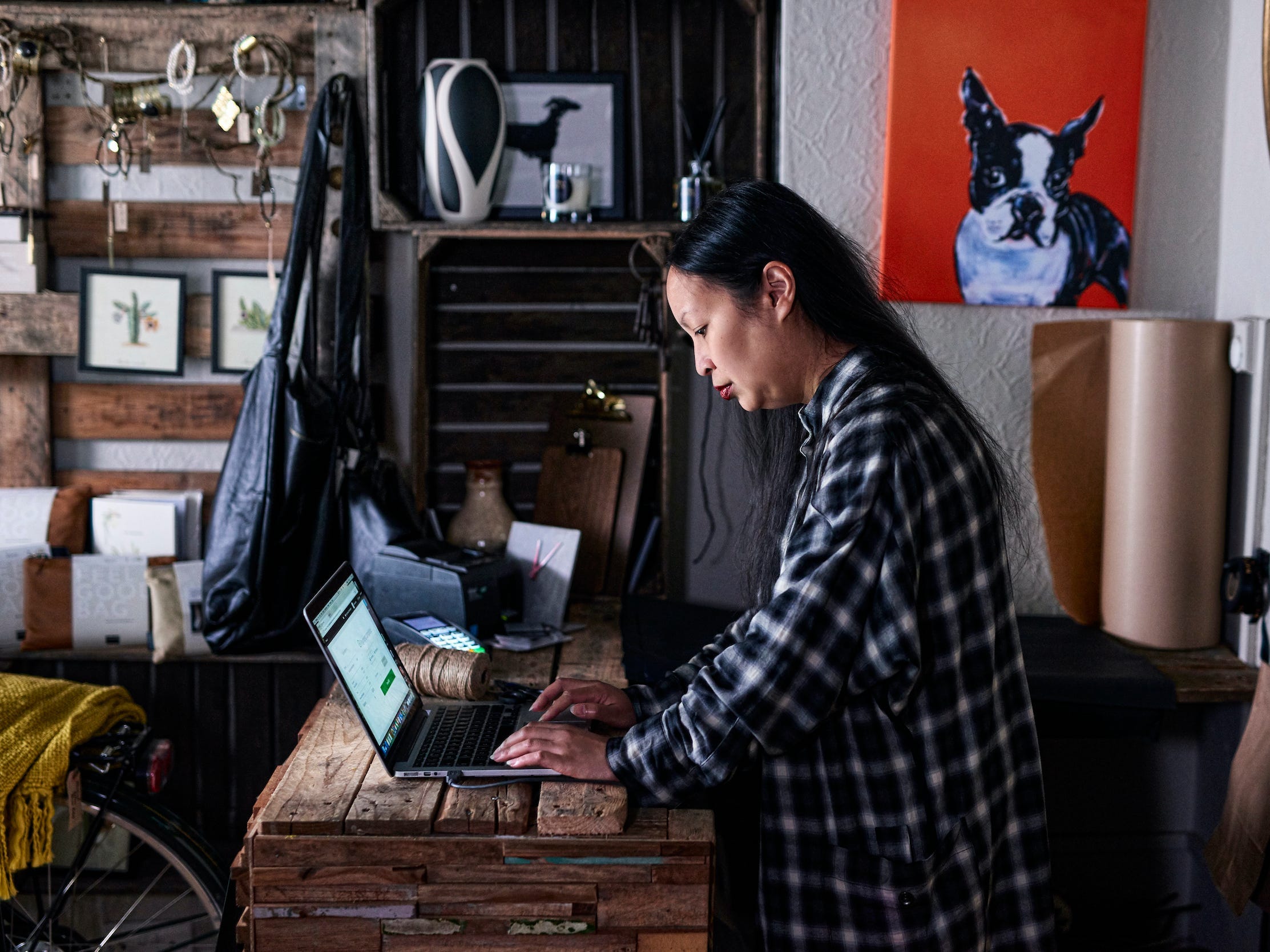 business owner using laptop in store