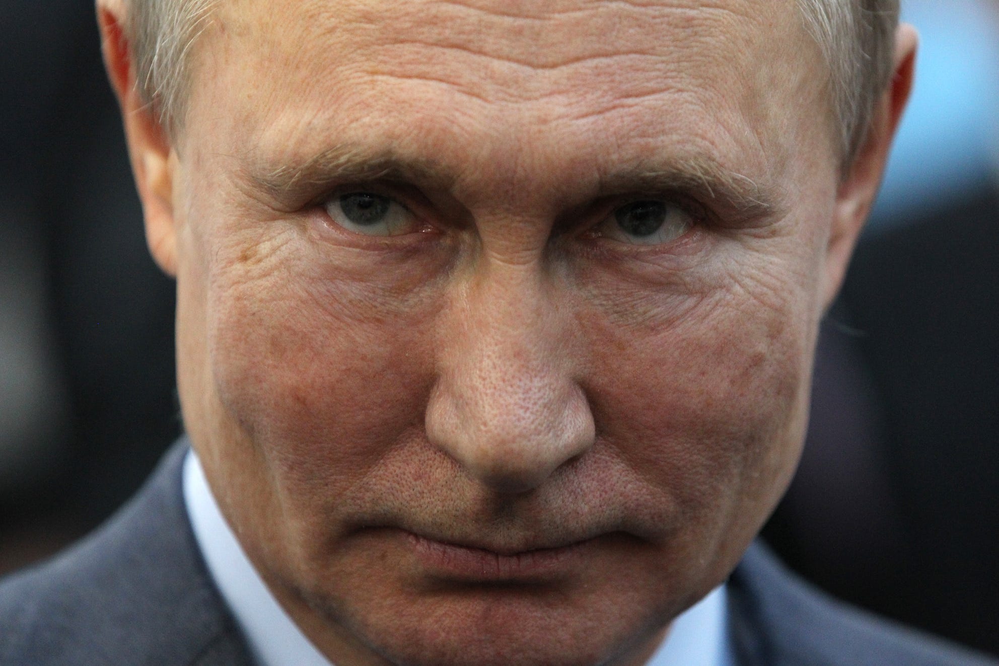 a close-up of putin's face with a slight smile