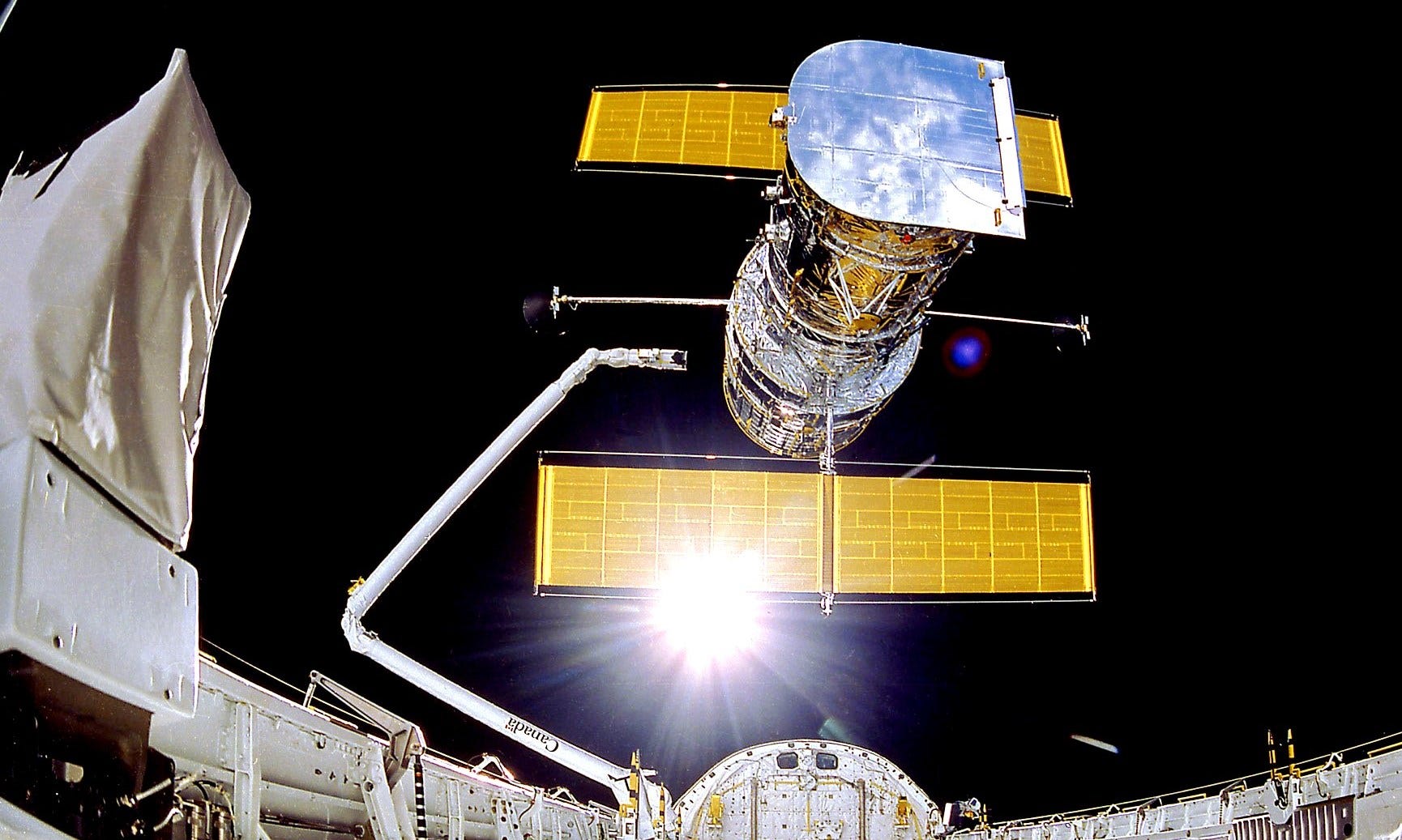 hubble space telesope deploys from space shuttle arm in earth orbit