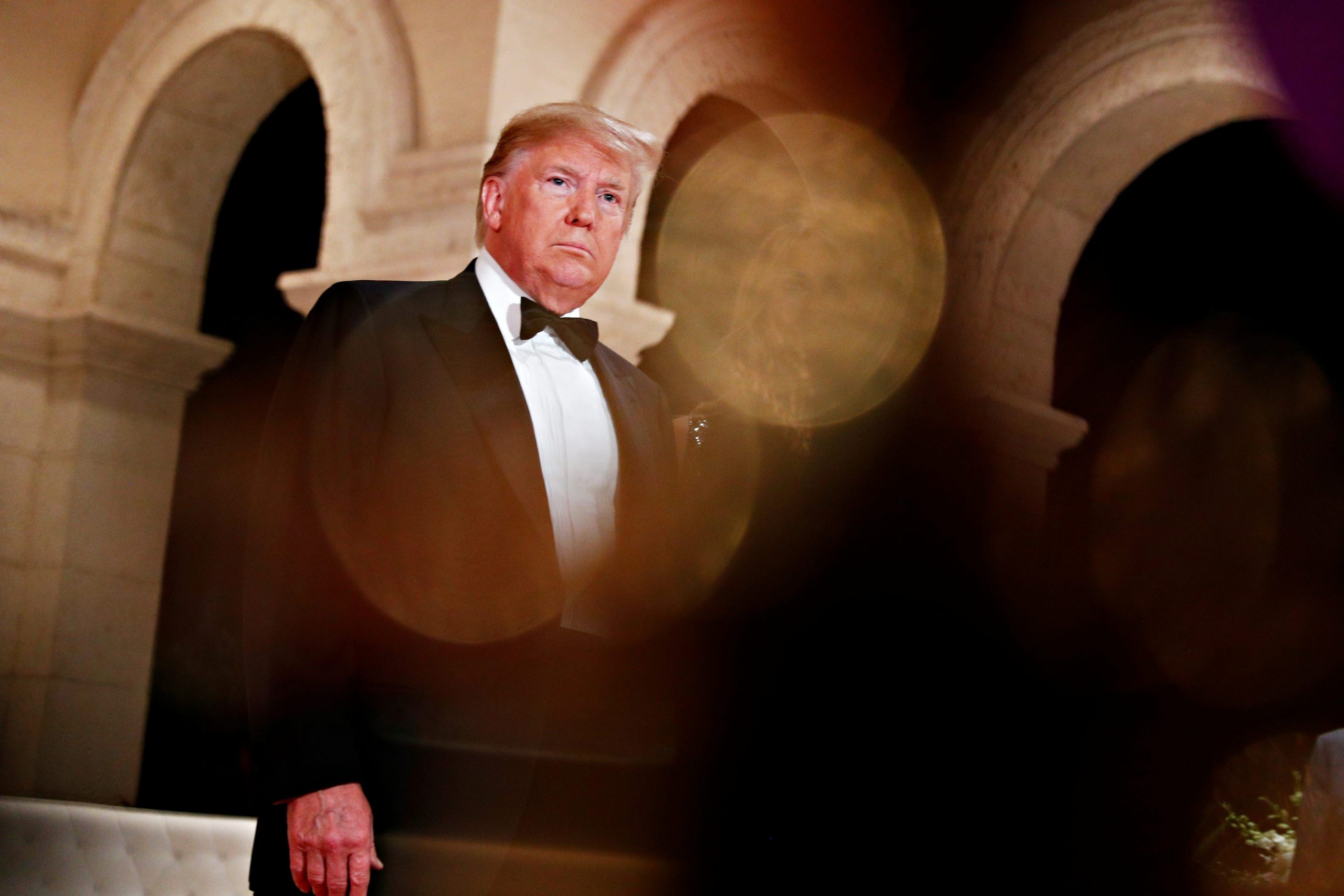 Trump in a black-and-white tuxedo under marble arches at Mar-a-Lago