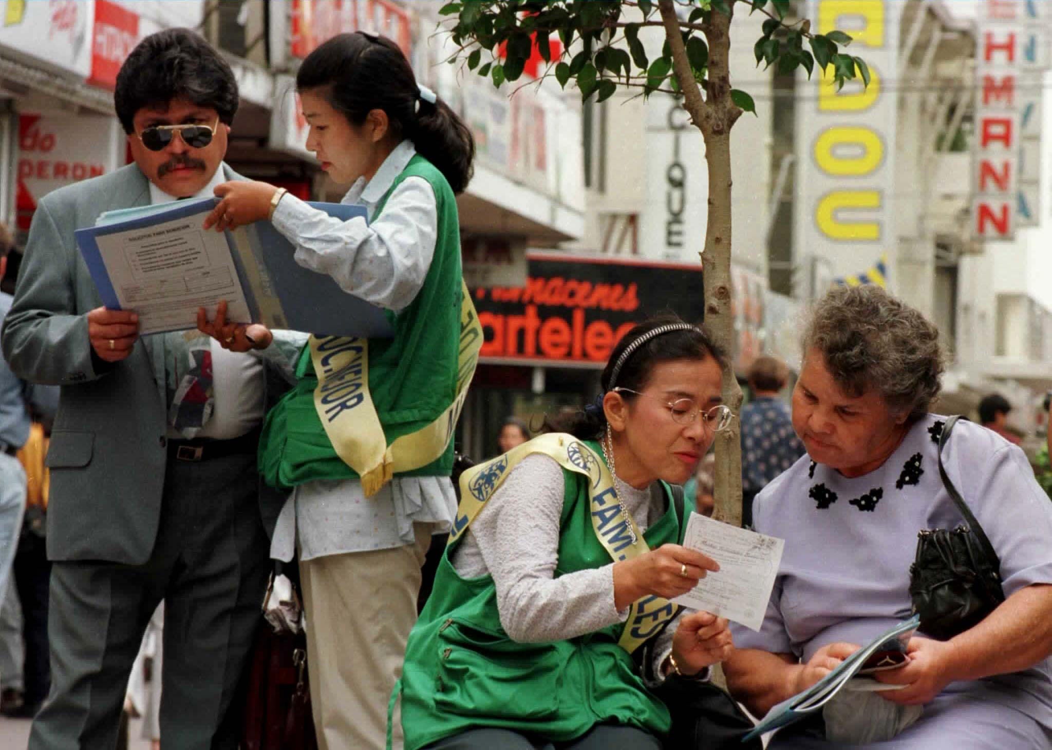 Unification Church members show documents to passersby on a street in 1997