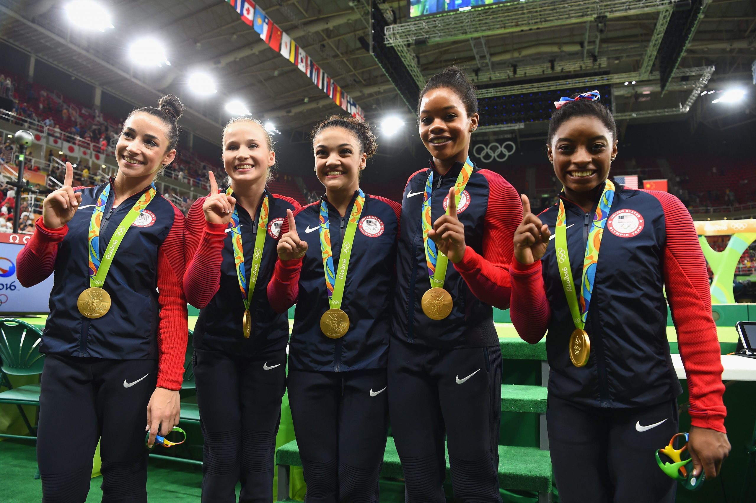 Alexandra Raisman, Madison Kocian, Lauren Hernandez, Gabrielle Douglas, and Simone Biles lined up in their warmup suits with their medals at the Rio 2016 Olympics.