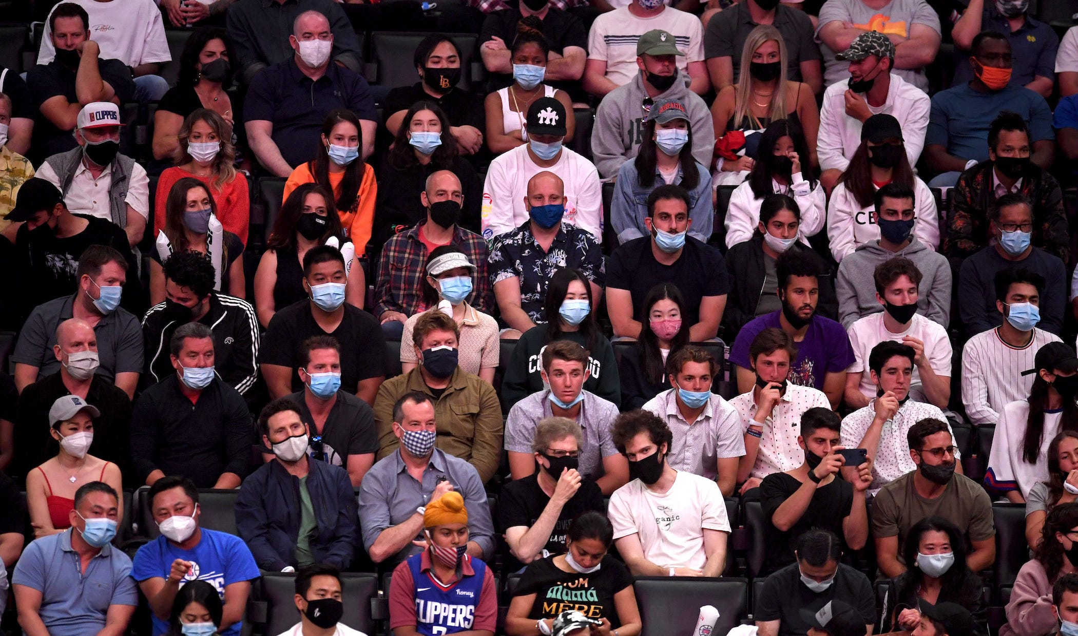 a crowd - all wearing face masks - at an NBA game