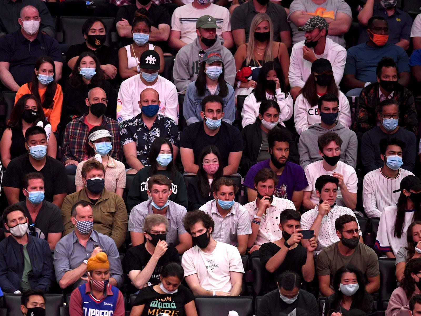 a crowd - all wearing face masks - at an NBA game