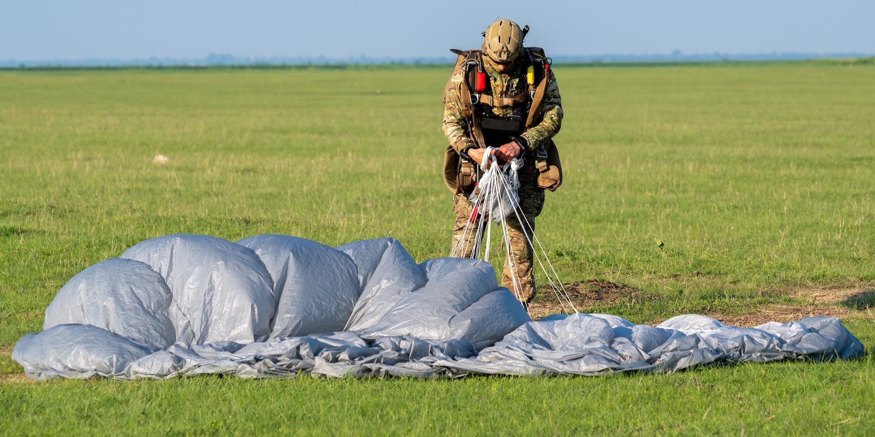 Air Force Special Operations Forces airman gathers parachute after jump