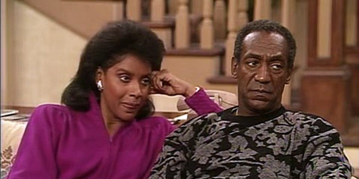 Phylicia Rashad and Bill Cosby sitting on a couch