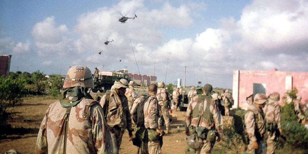 Army soldiers of Company B, 2nd Battalion, 14th Infantry Regiment, watch helicopter activity over Mogadishu, Oct. 3, 1993