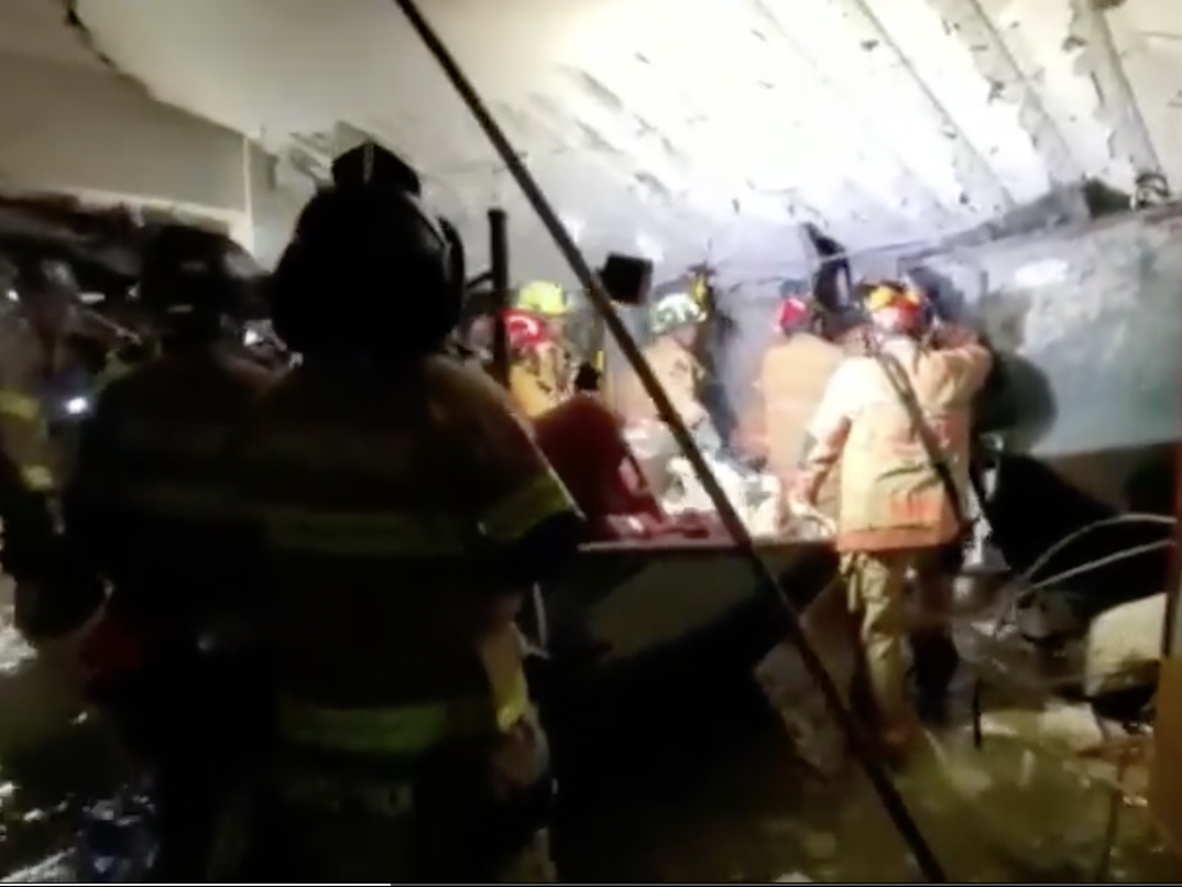 Firefighters work to rescue survivors underneath the Florida condo tower that collapsed.