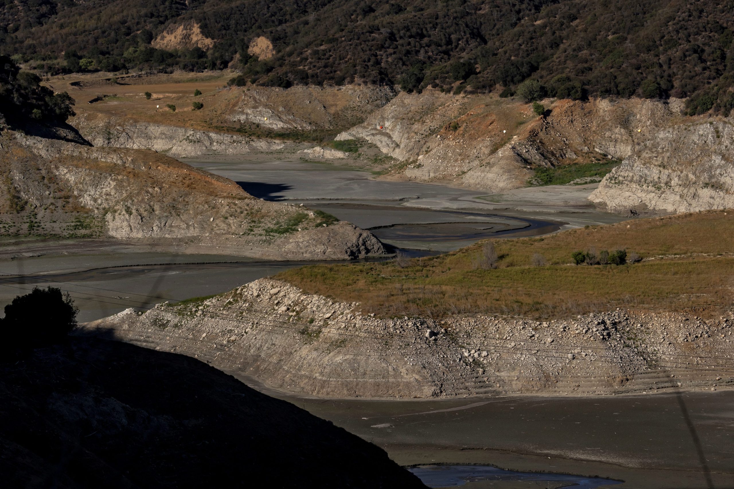 The barren, dry landscape is seen around the reservoir.