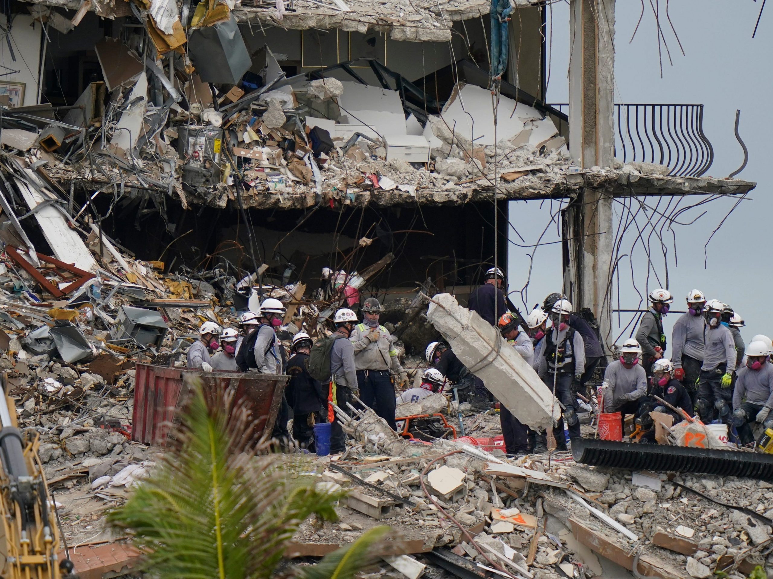 Search and rescue personnel work atop the rubble at the collapsed Champlain Towers South condo building.