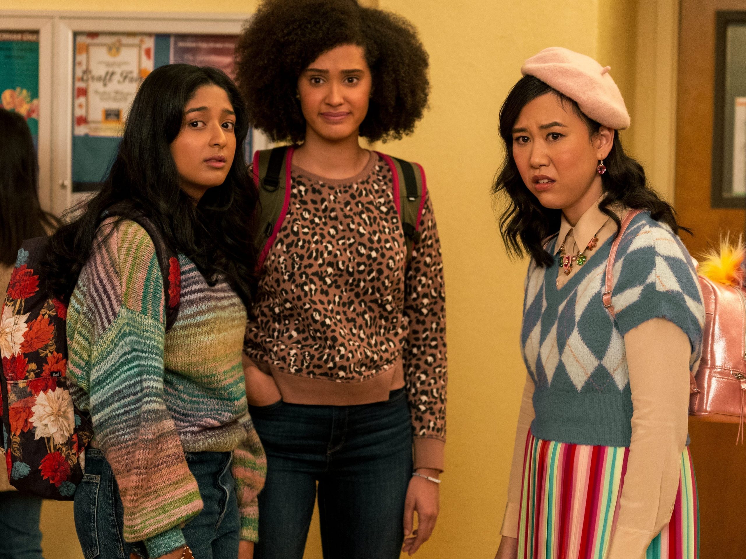 From left: Maitreyi Ramakrishnan, Lee Rodriguez, and Ramona Young standing in a school hallway on season two of "Never Have I Ever."