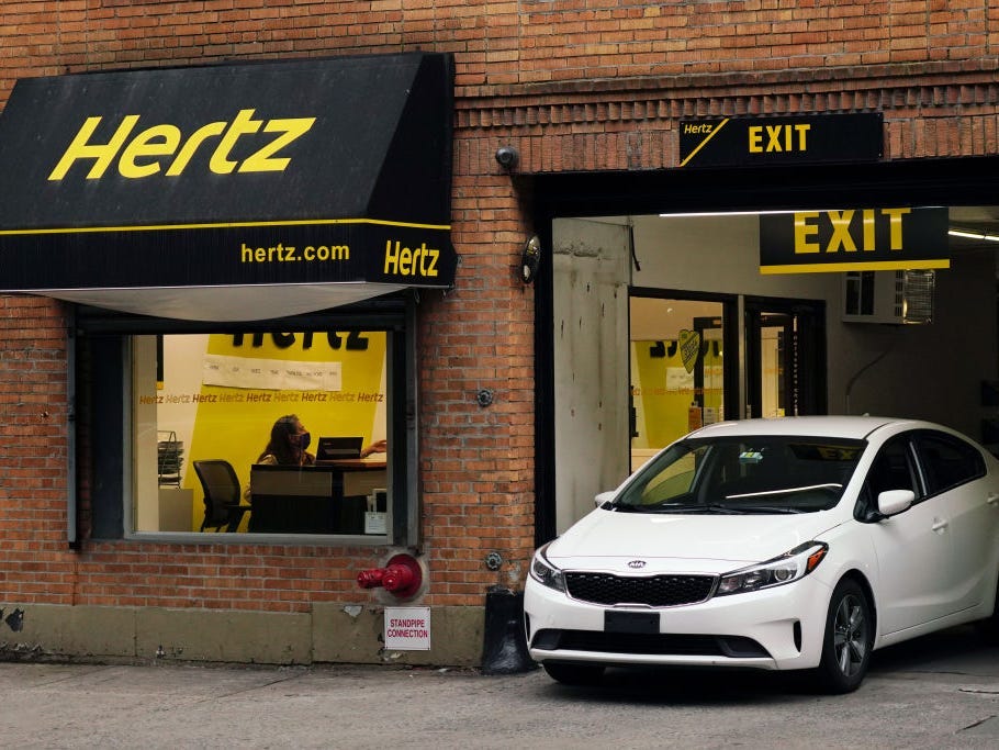 A white car pulling out of Hertz